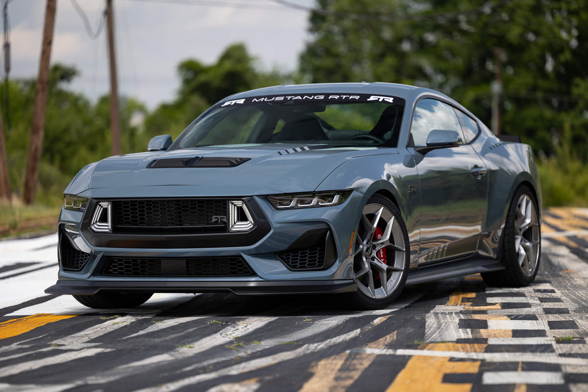 A 2024 Mustang RTR Spec 2 on a road, showcasing its RTR parts and accessories like the grille and wheels