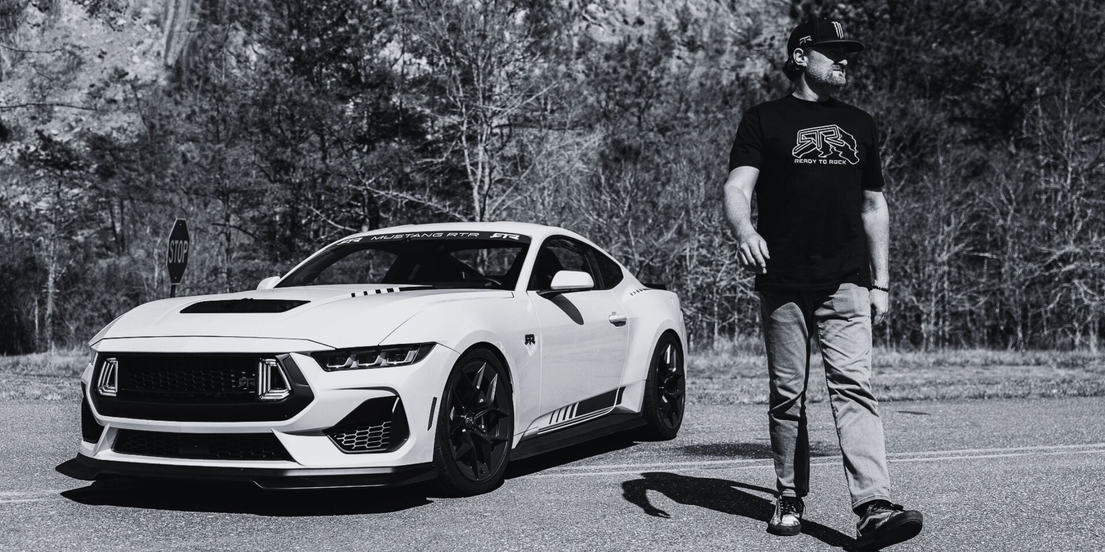 White sports car on a road with a person standing next to it
