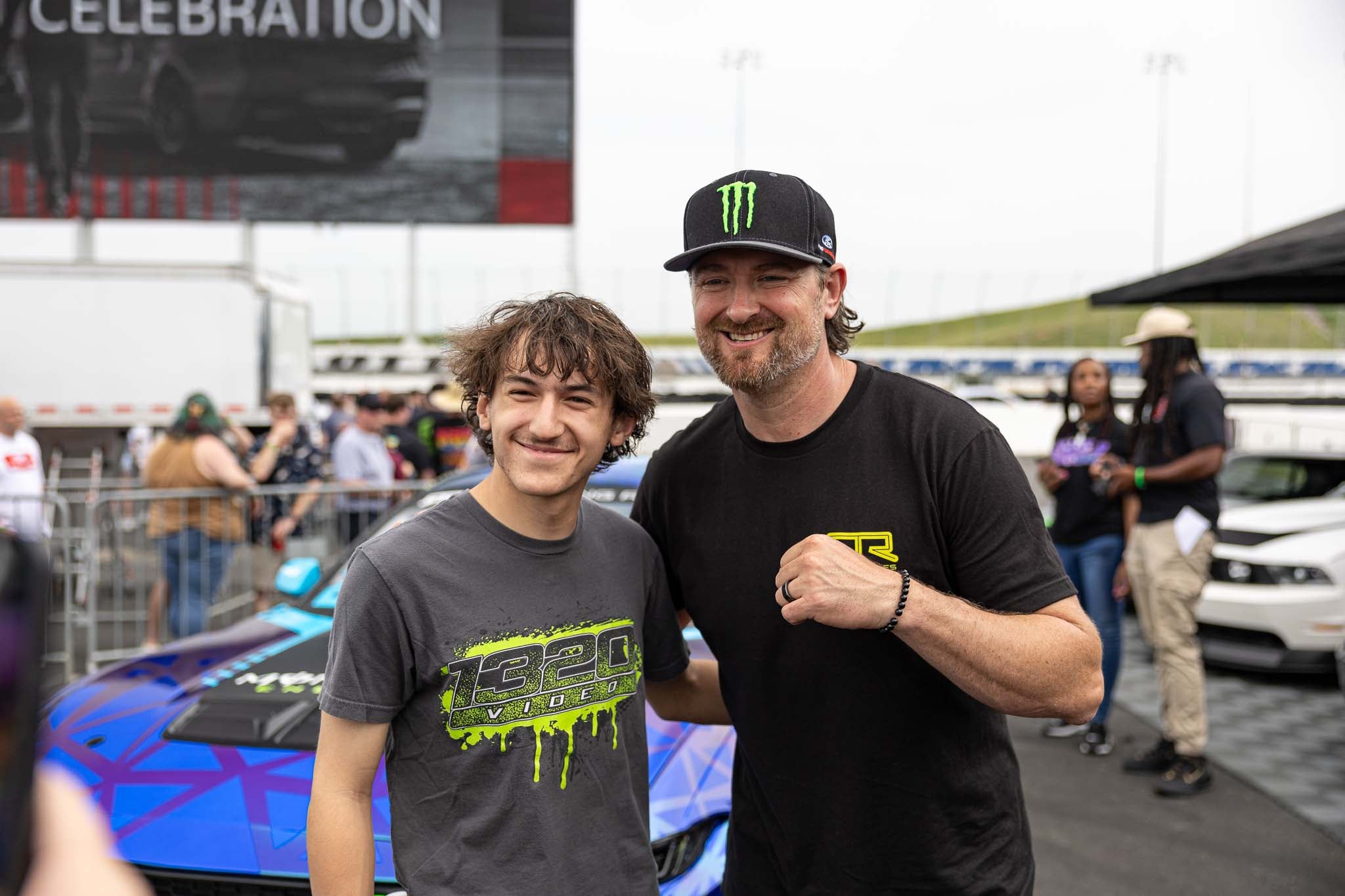 Vaughn Gittin Jr takes a photo with a fan during the Mustang 60th Anniversary