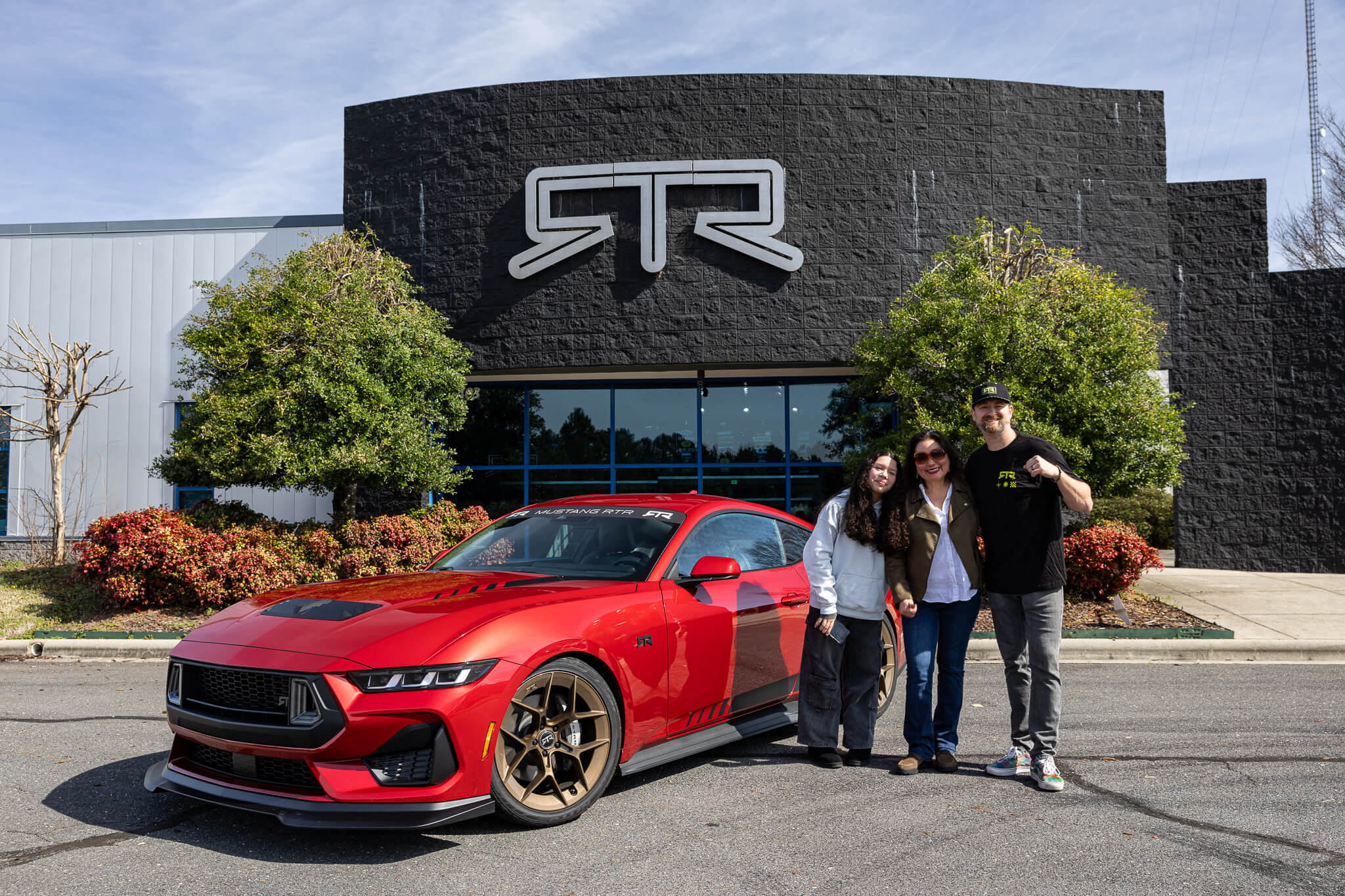 RTR owners take a picture with Vaughn in front of the RTR Lab with their 2024 Mustang RTR