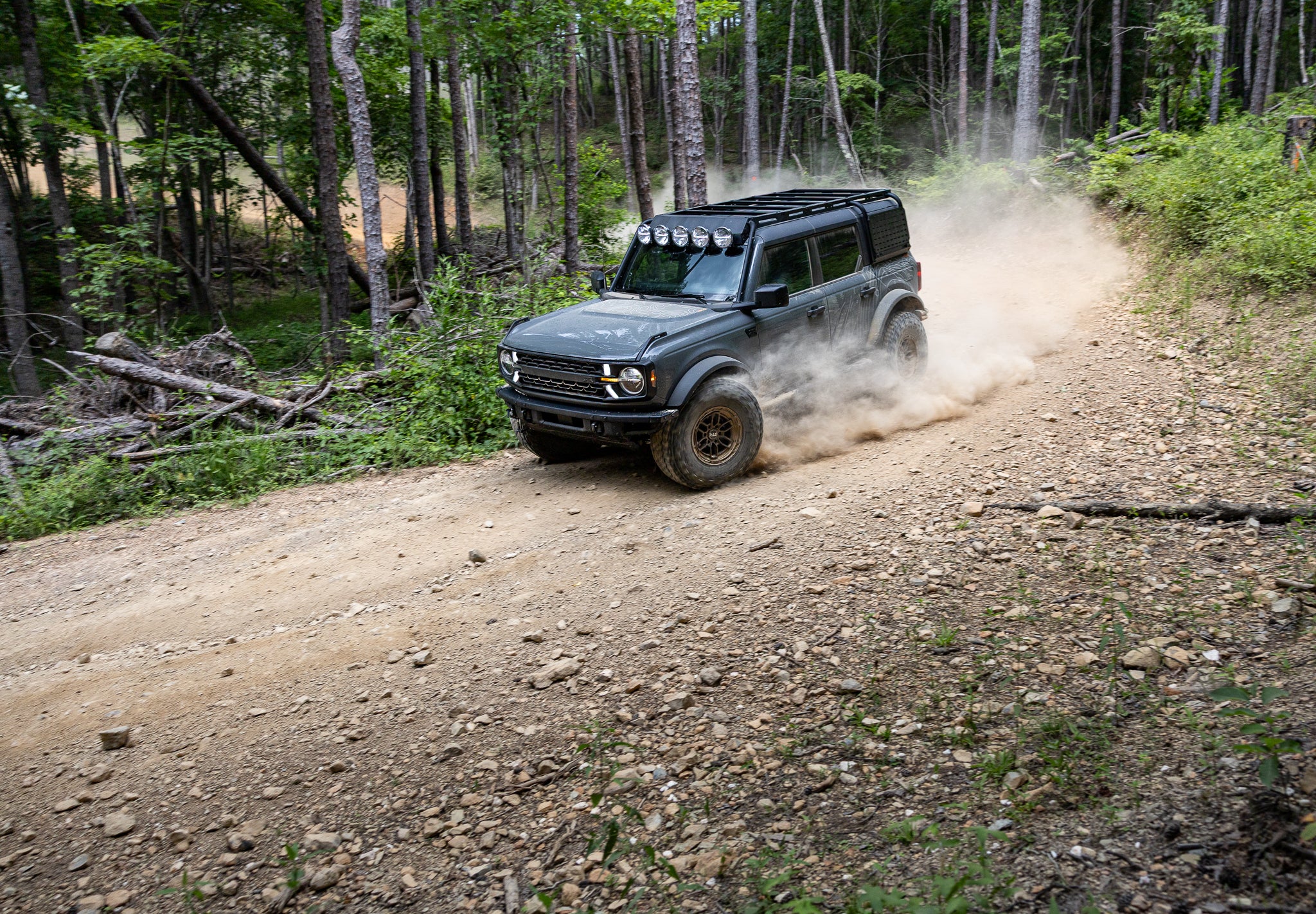 A Bronco RTR ROVR driving on a dirt road in a forest