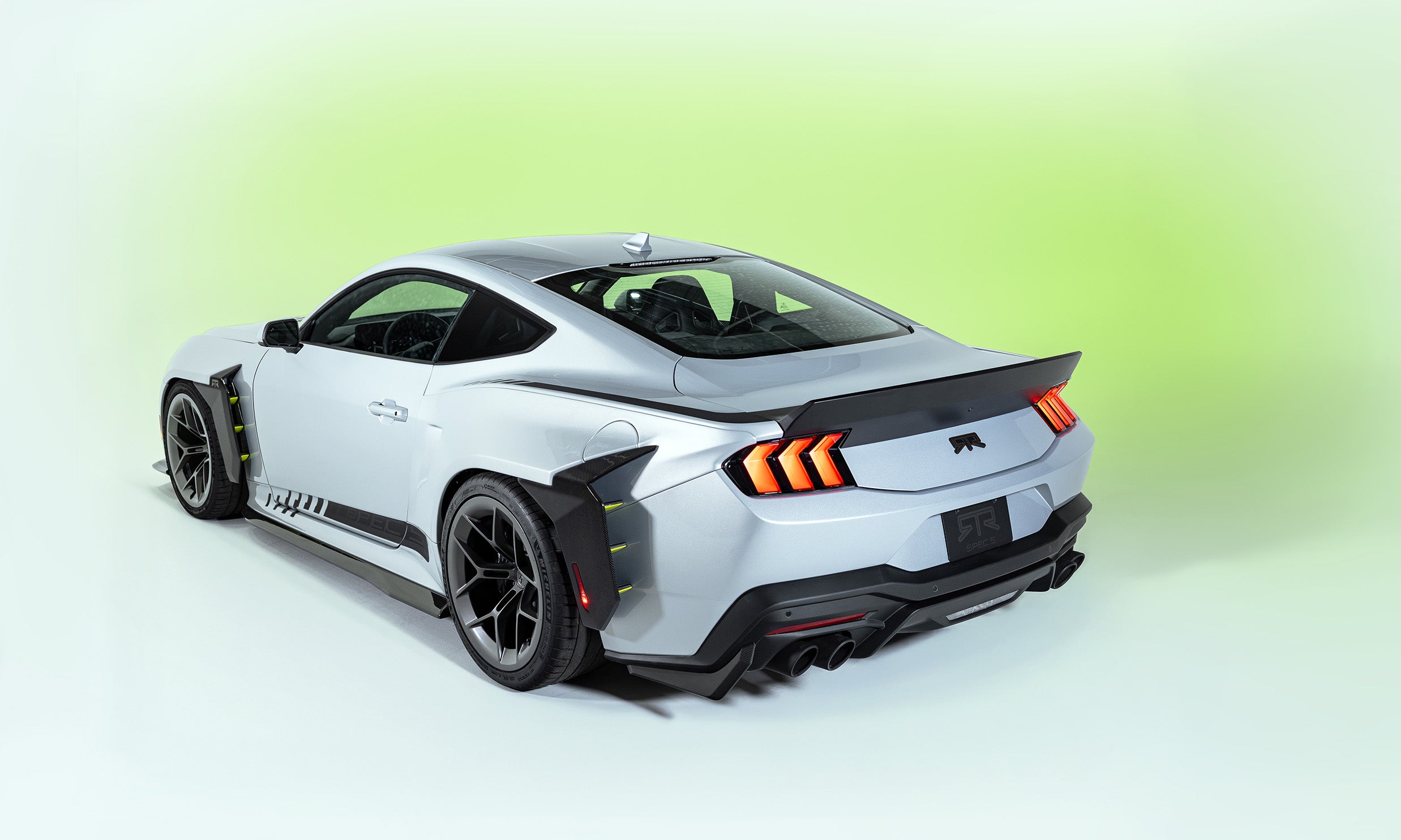 Rear view of the 2026 Mustang RTR Spec 5 on a white and hyperlime background, showcasing RTR's evolution of design and performance