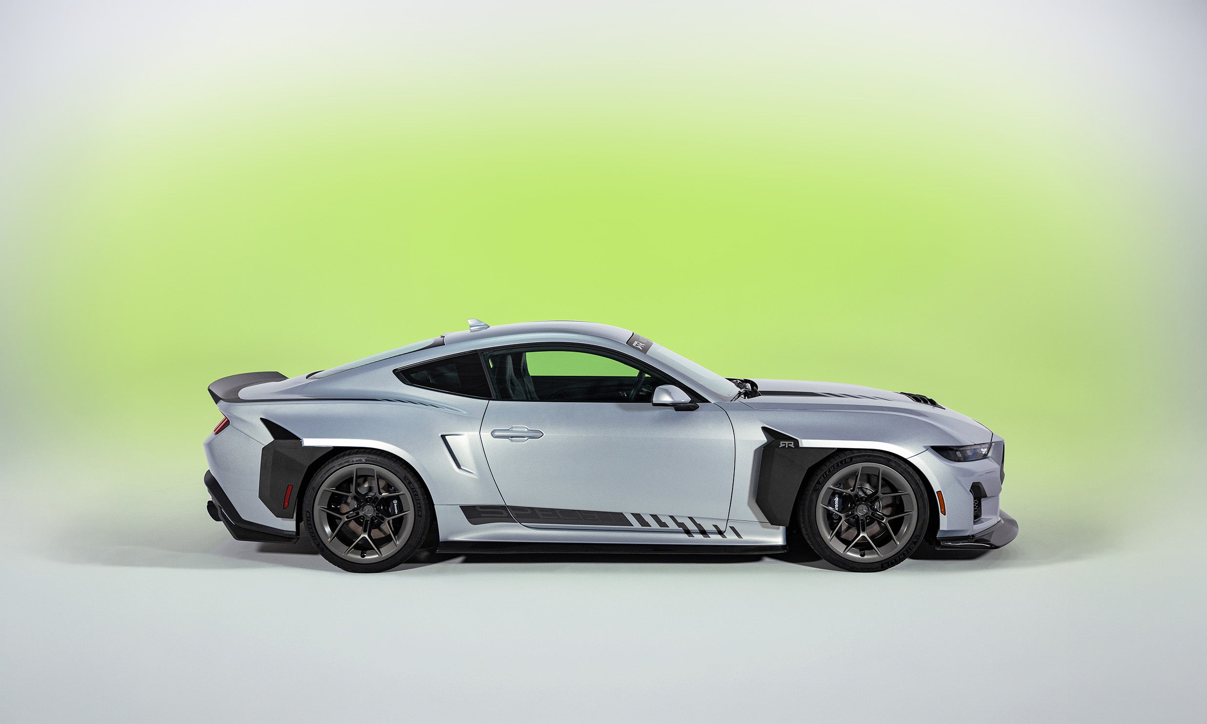 Side profile view of the 2026 Mustang RTR Spec 5 on a white and hyperlime background, showcasing RTR's evolution of design and performance