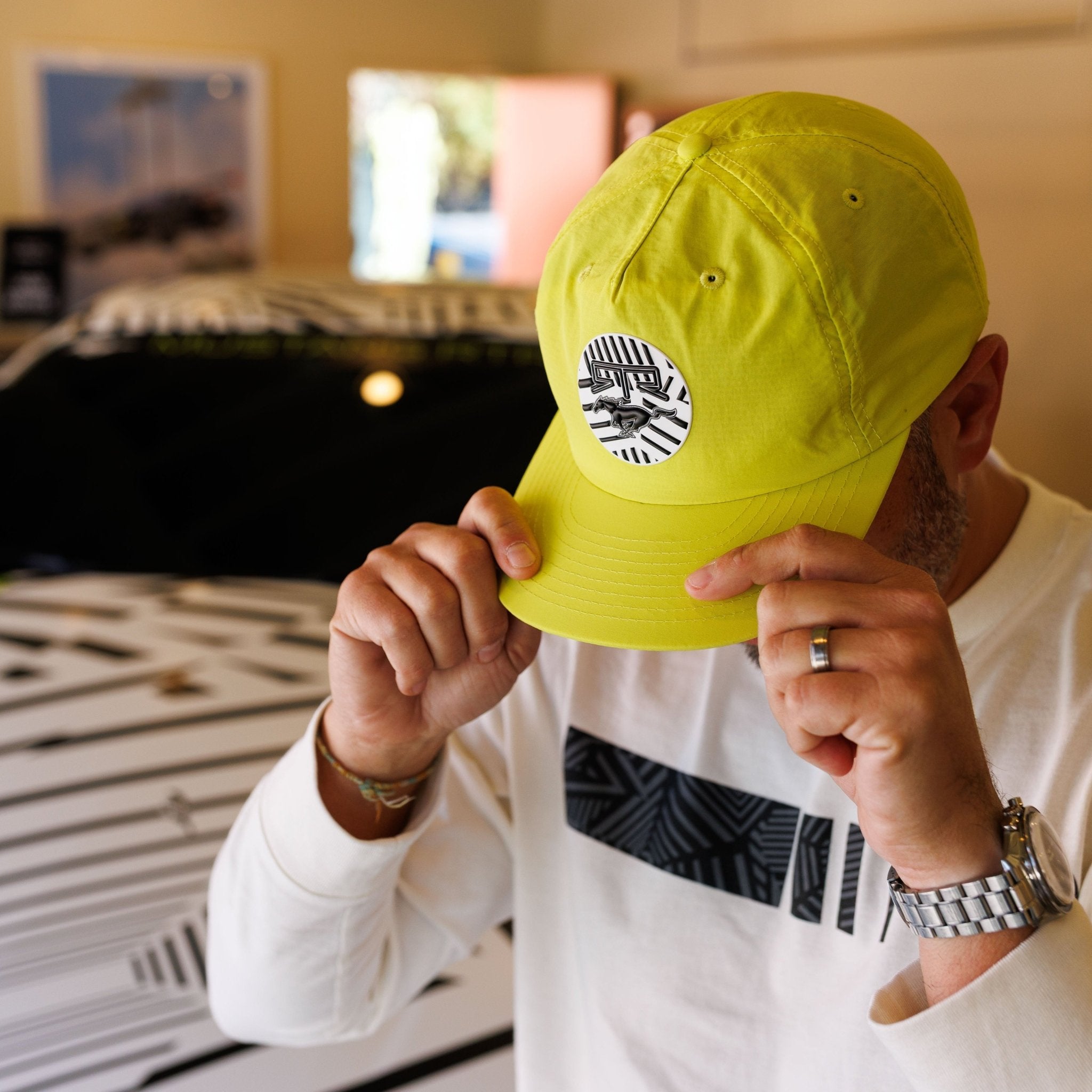Person wearing a Ford Mustang x RTR Collection 5 Panel Unstructured Snapback Hat, showcasing the emblem and design details, in a studio setting.
