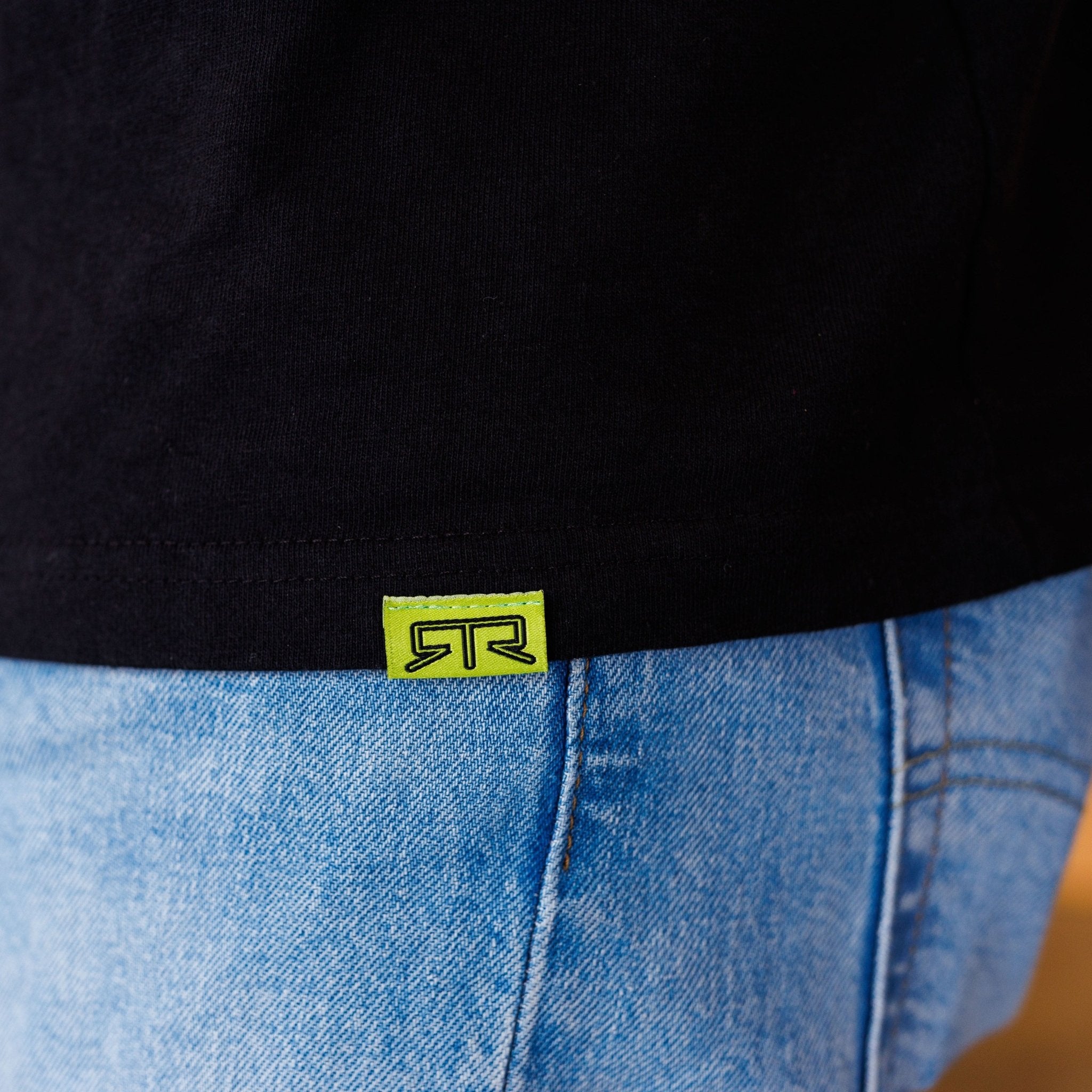 Close-up of Ford Mustang x RTR Collection Pocket T-Shirt with a neon-green tag and stylized logo, highlighting the limited-edition design and signature pocket.