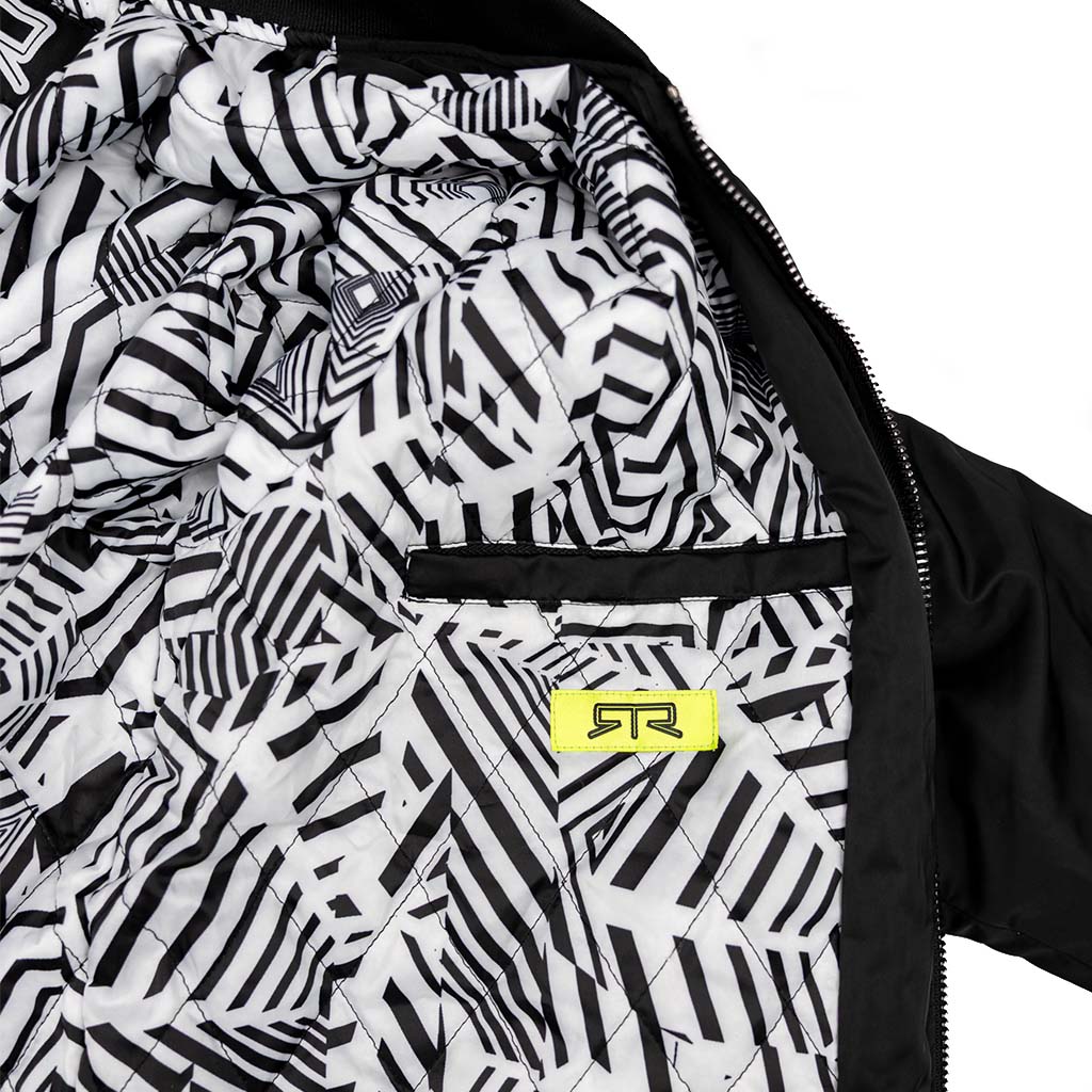 Close-up of the RTR Stealth jacket with RTR dazzle camo pattern quilted lining and a black and hyperlime RTR label