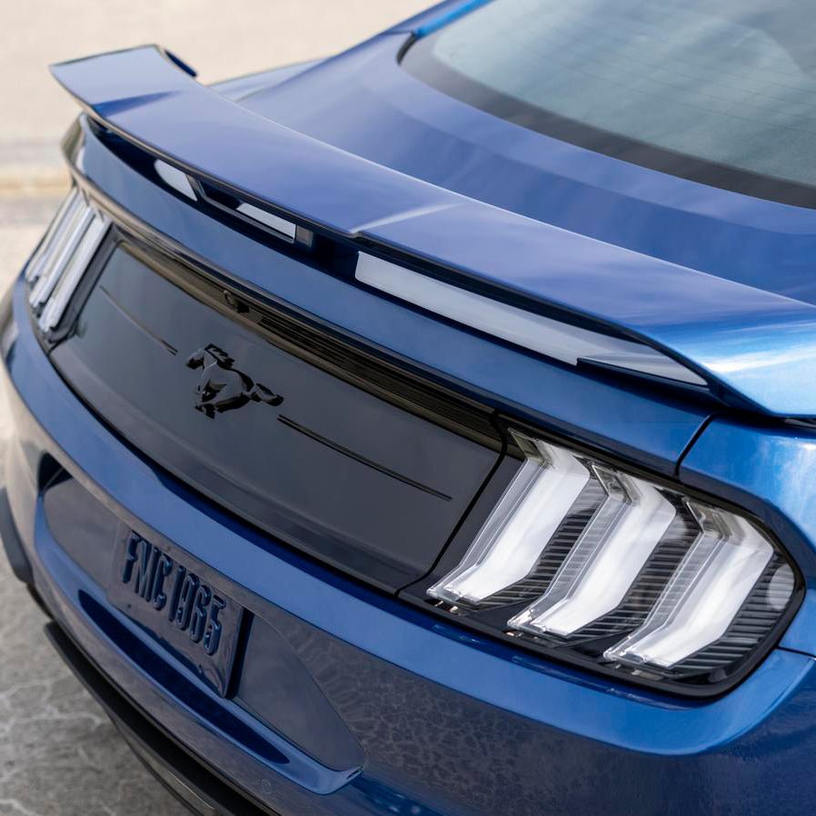Close-up of Ford Performance Clear Tail Lamp Kit on a blue Mustang, showcasing clear lenses, LED illumination, and sequential turn signals for a sleek, modern rear profile.