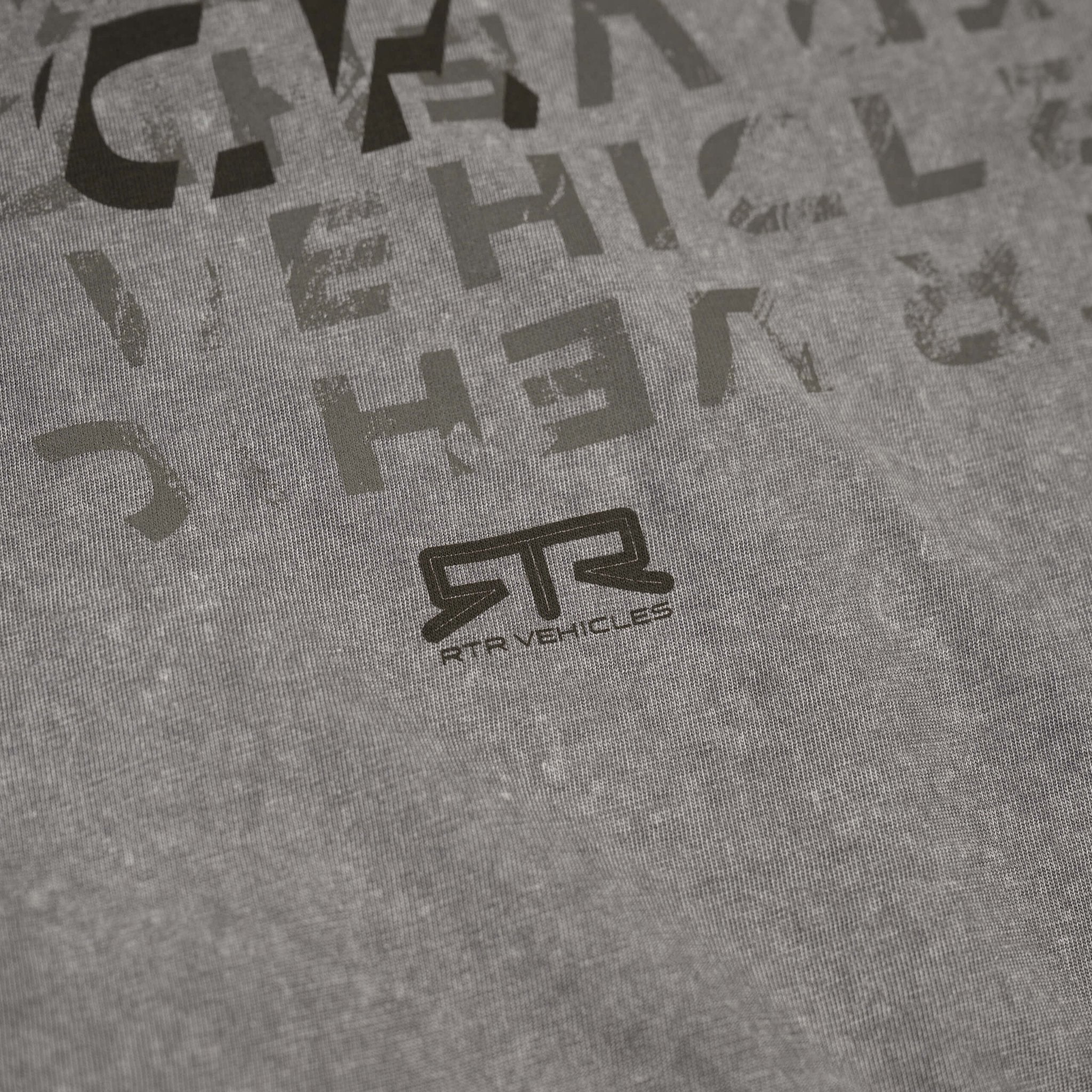 Close-up of the RTR Distressed T-Shirt's knitted fabric, showcasing its soft texture and subtle detailing, with a focus on the tonal RTR logo.