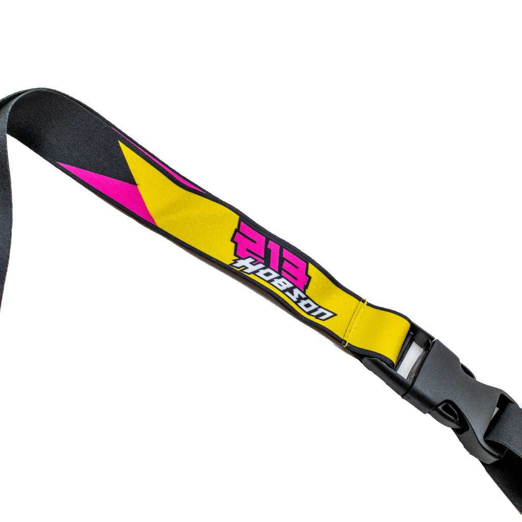 RTR Drift Team Lanyard featuring a black strap with yellow accents, metal hook, and printed team liveries, showcasing the RTR® logo and speed block pattern.