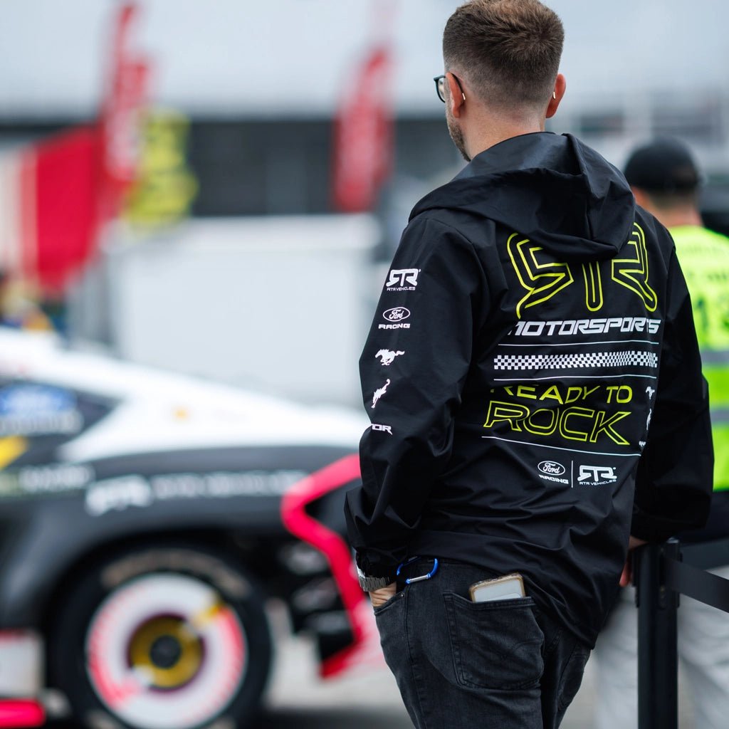 RTR Team member wearing the Black and Hyperlime RTR Motorsports Windbreaker Waterproof Jacket at Formula Drift.