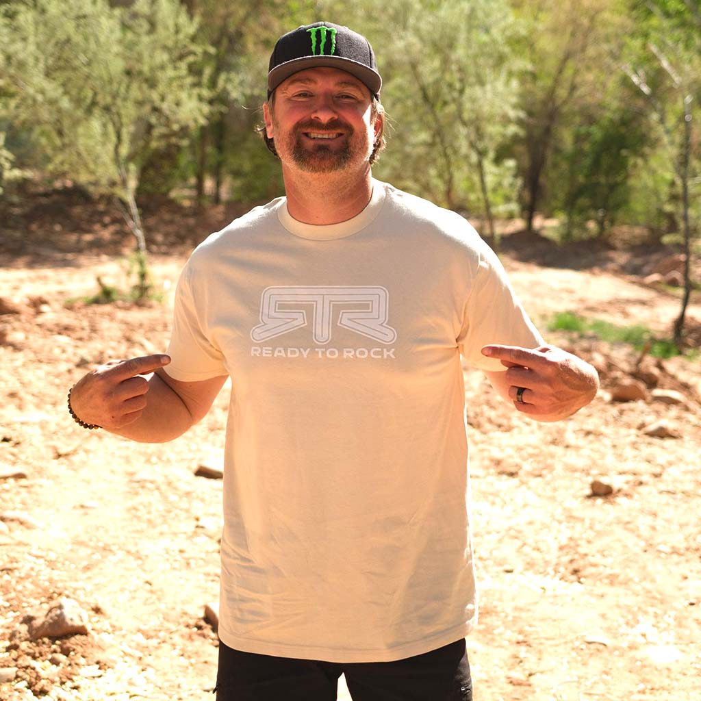 Close-up of a man smiling, wearing the RTR Tonal Logo T-Shirt, showcasing its comfortable fit and subtle logo detailing, ideal for everyday wear.