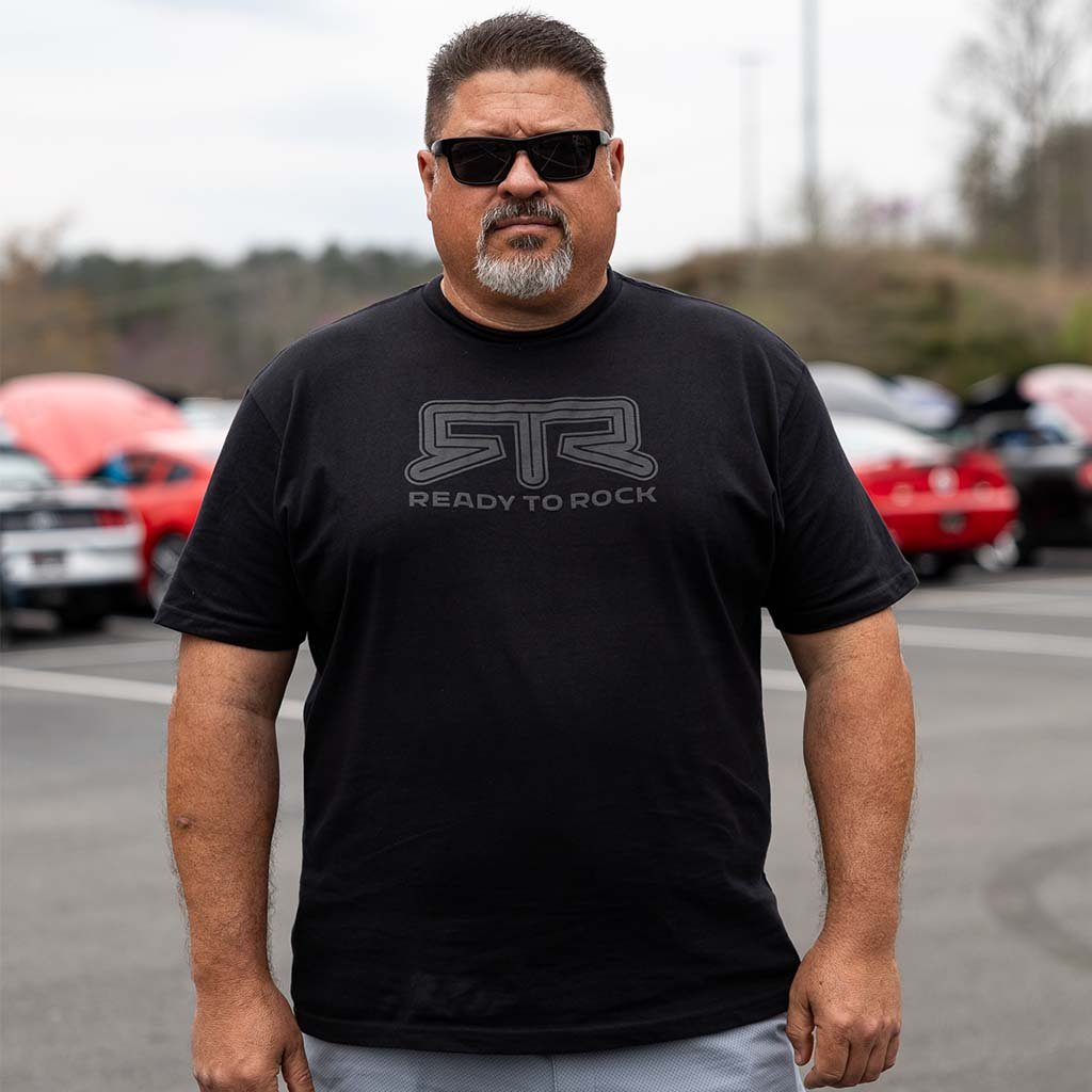 Close-up of a person wearing the RTR Tonal Logo T-Shirt, showcasing the subtle puff print logo and Ready to Rock™ slogan, highlighting its casual style.