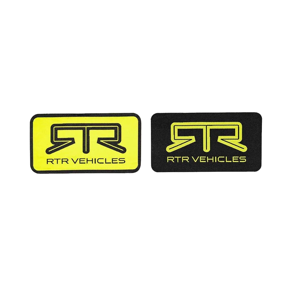 Two RTR Vehicles logo patches, one yellow and one black, on a white background.