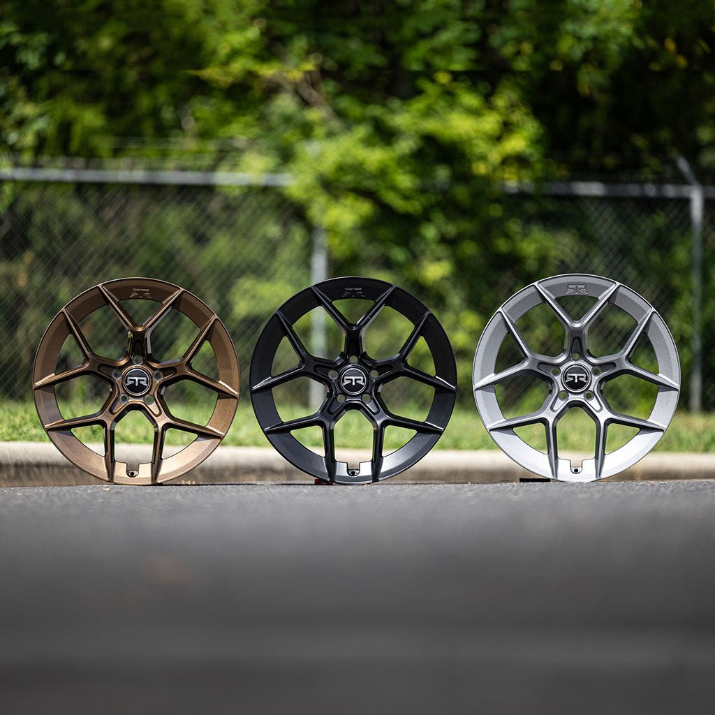A close-up of black, charcoal and bronze RTR Aero 5 wheels on a road, showcasing wheel details with RTR logos.