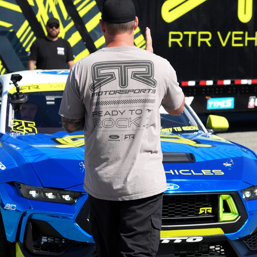 RTR Vehicles crew member wearing the Vintage Grey 2026 RTR Motorsport Collection Vintage short sleeve T-Shirt in the pits at Laguna Seca.