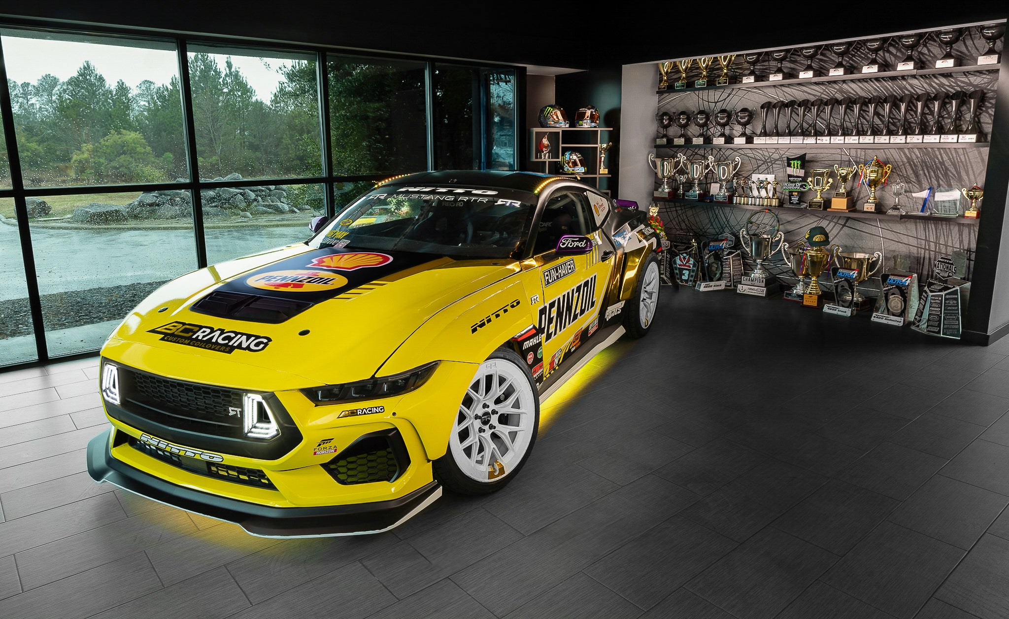 Chelsea DeNofa's Mustang RTR in front of RTR trophy case