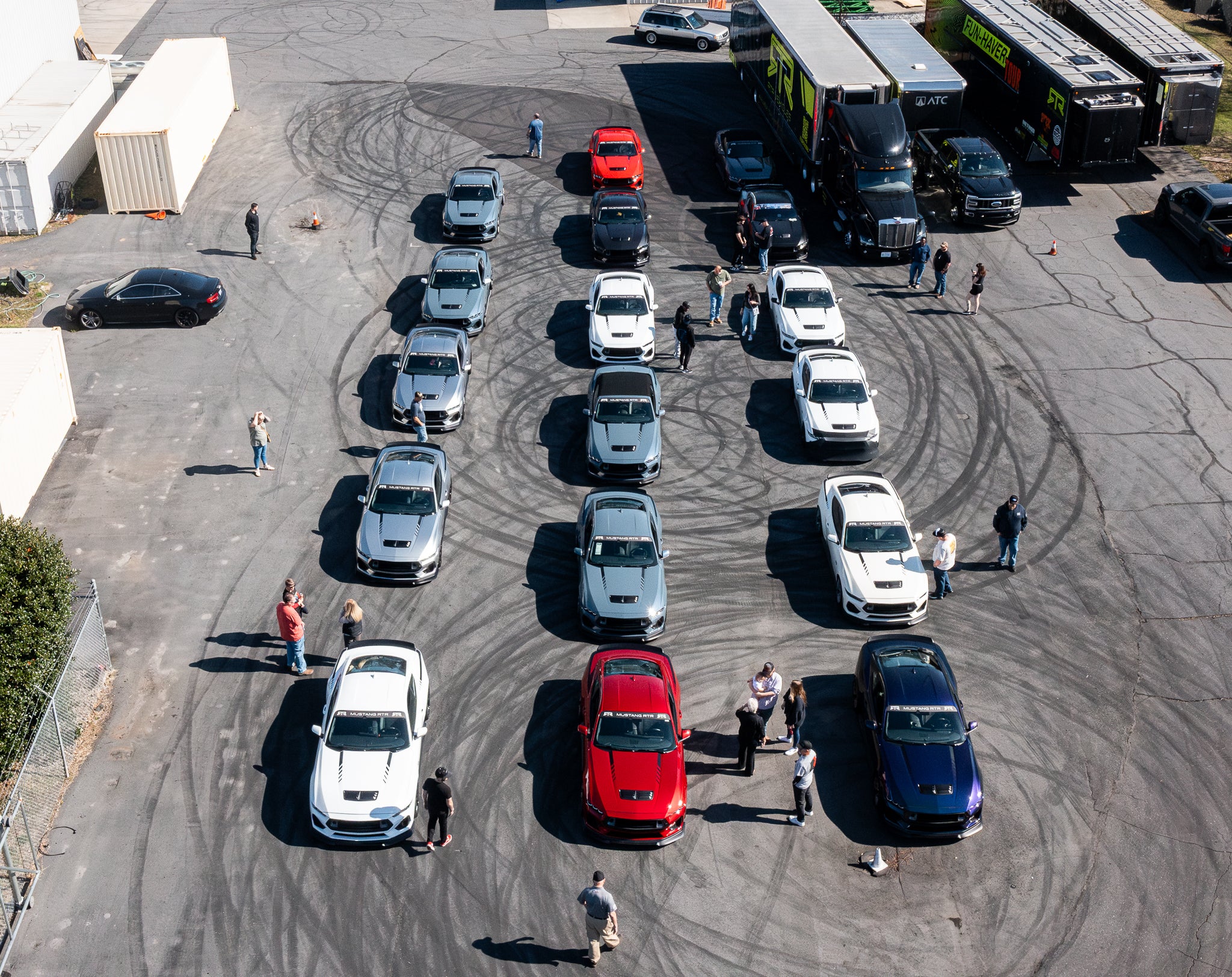 Overhead view of a lineup of Mustang RTR owners mingling around their cars at the RTR Lab