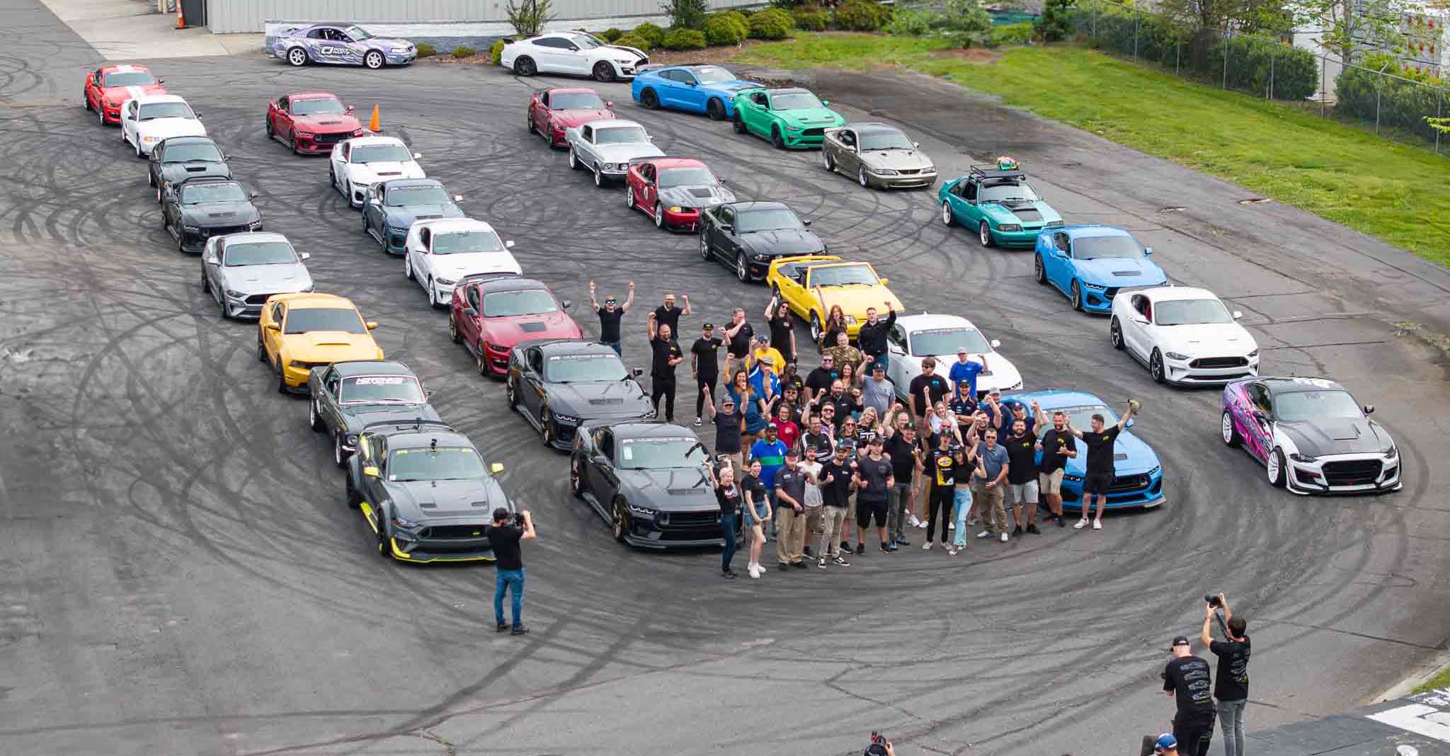 A group of Mustang owners of all different generations of Mustangs gather outside the RTR Lab