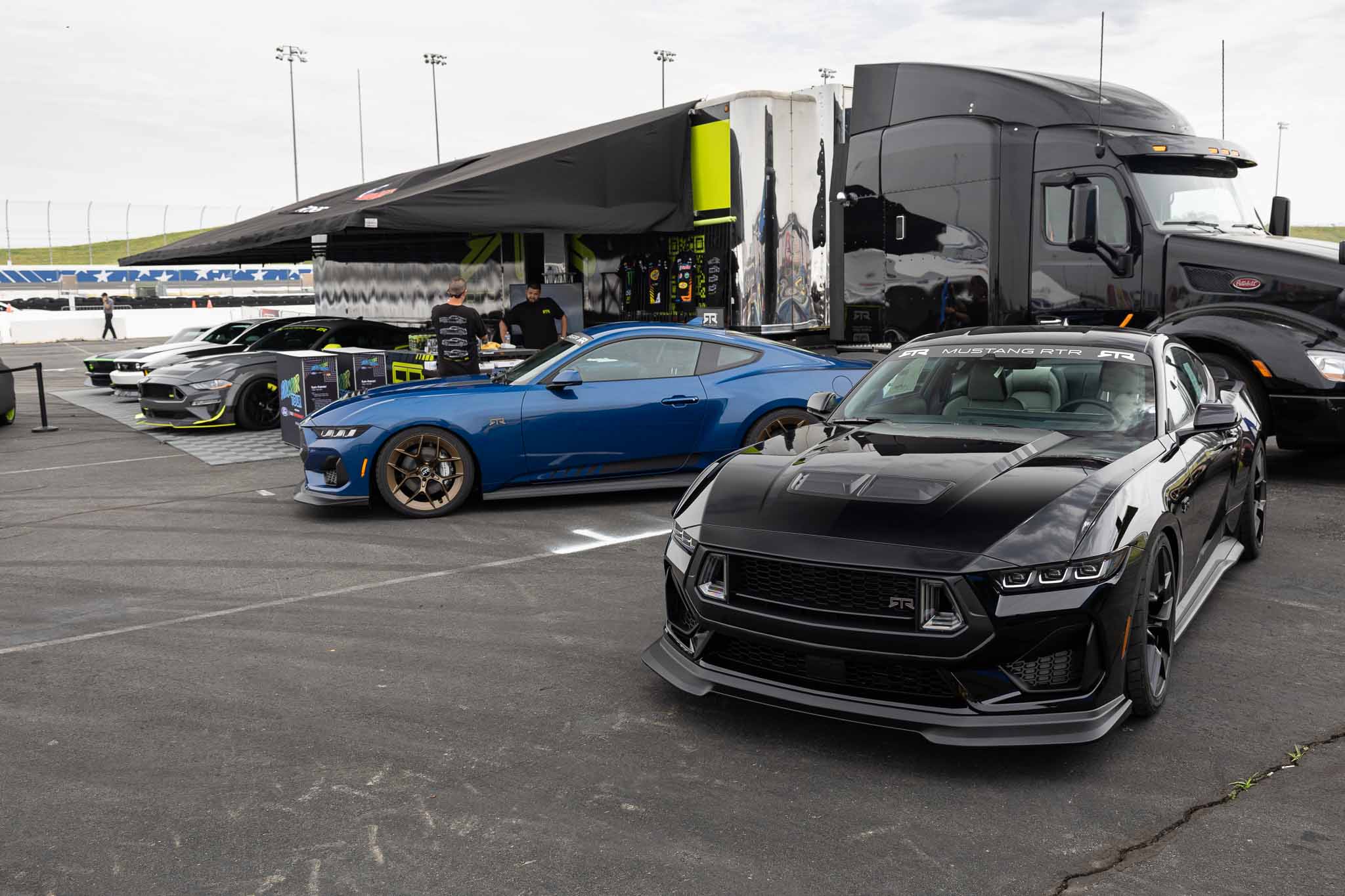 Two new 2024 Mustang RTRs parked in front of the RTR Booth at Charlotte Motor Speedway