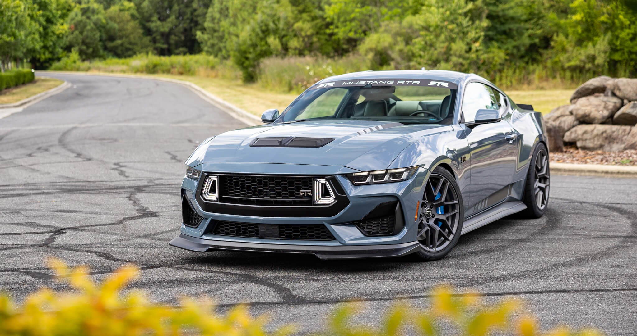 A vapor blue 2024 s650 Mustang RTR Spec 3 on an asphalt road