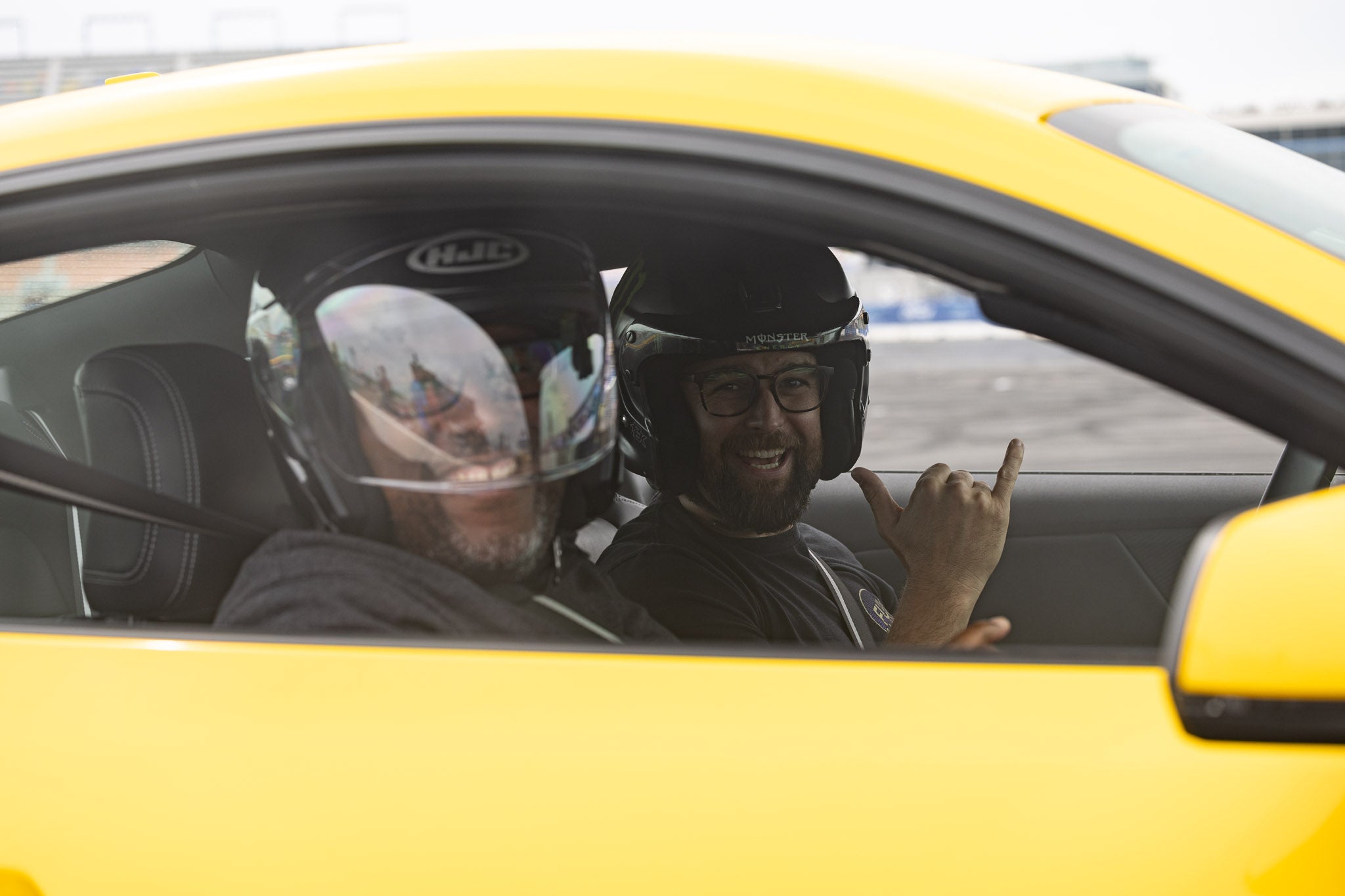Two men smile for the camera as they enjoy a ride in a 2024 Mustang