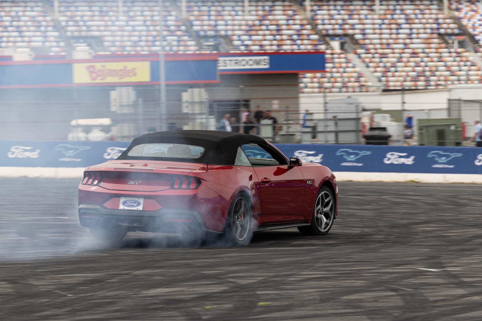 A red 2024 Mustang drifts at Charlotte Motor Speedway