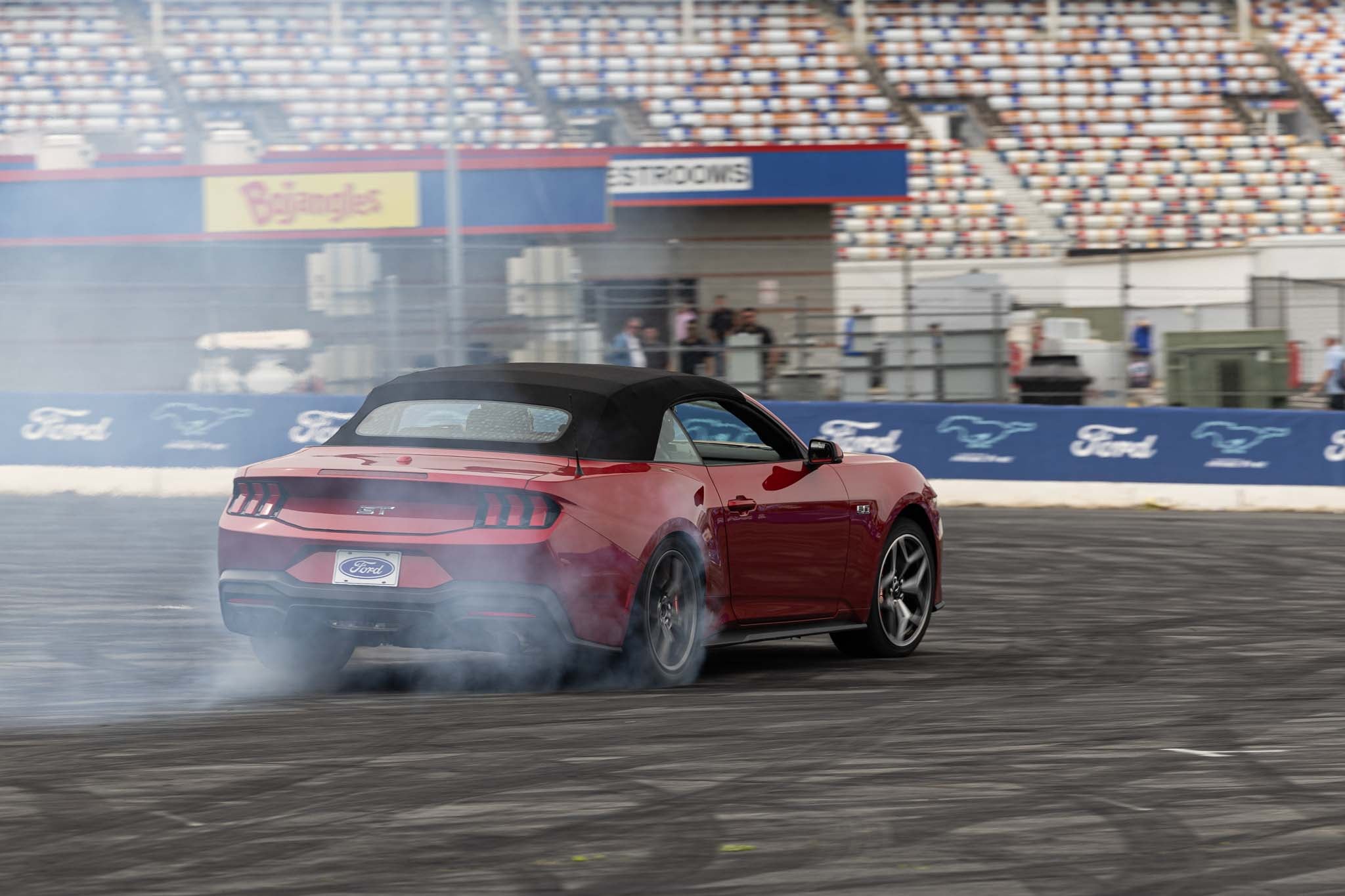 A red 2024 Mustang drifts at Charlotte Motor Speedway
