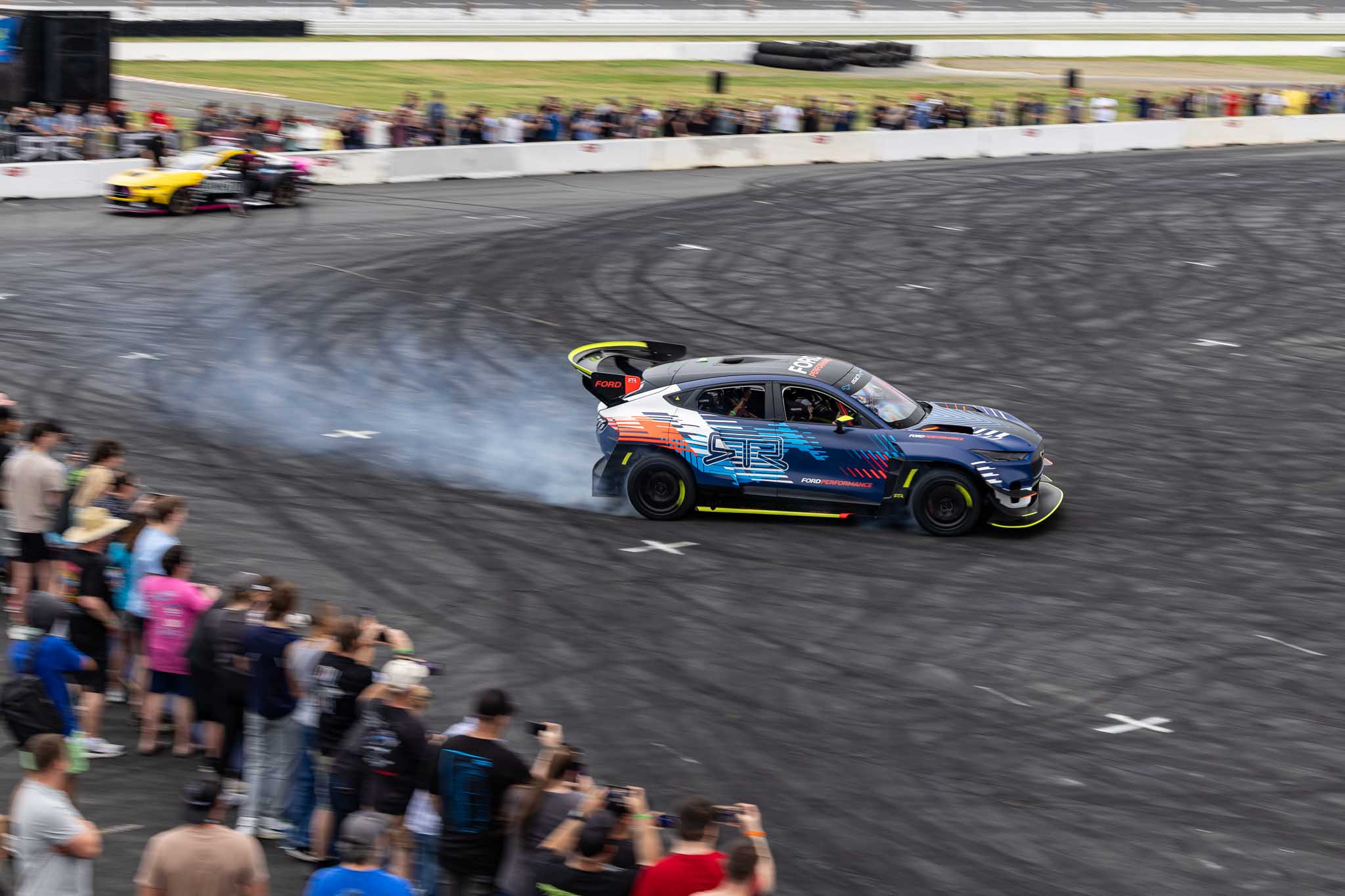 Chelsea DeNofa drives the Mustang Mach-E 1400 in front of a crowd at CMS