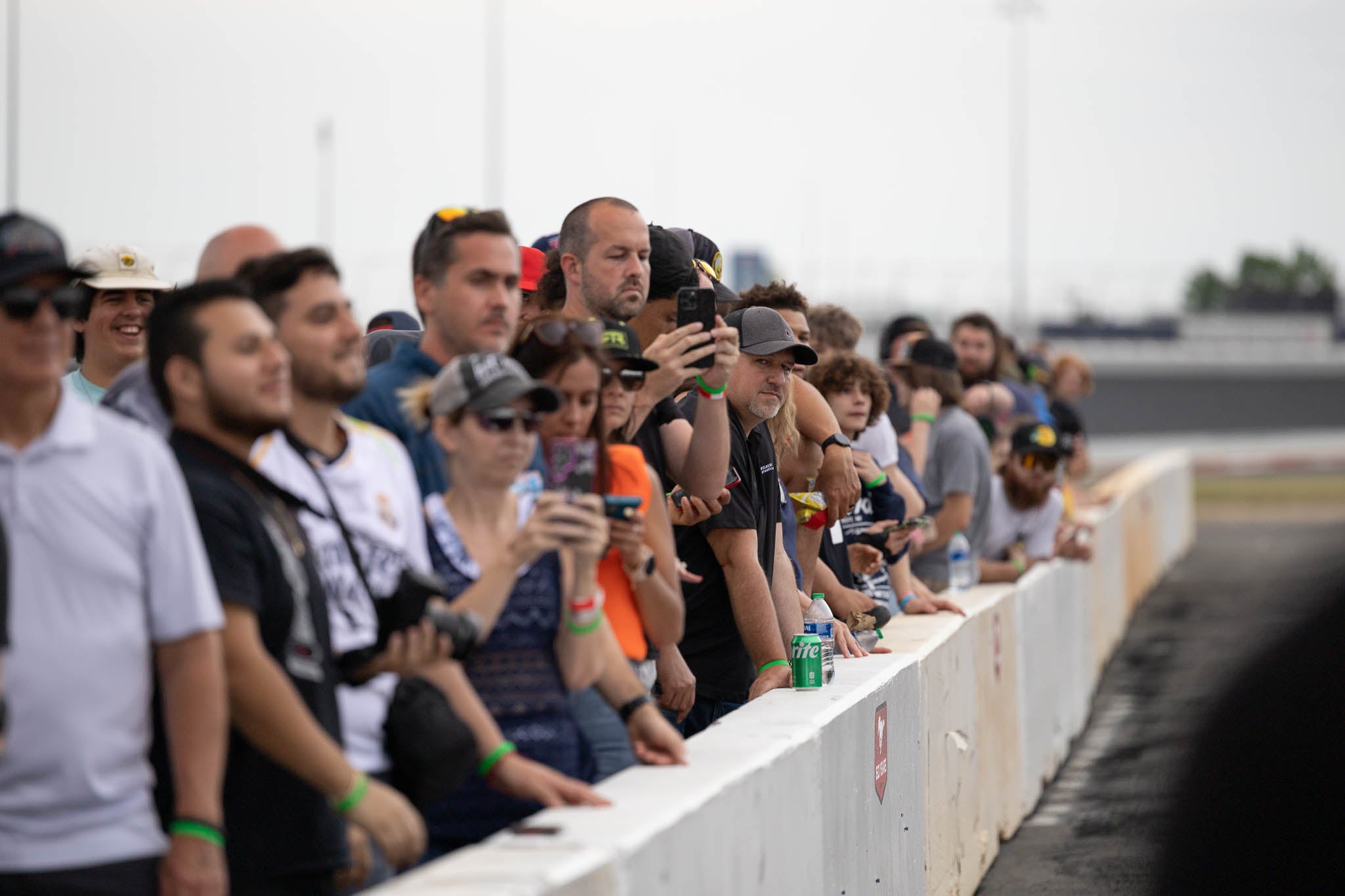 a crowd of people watch the Mustang drift demos at the Mustang 60th Anniversary