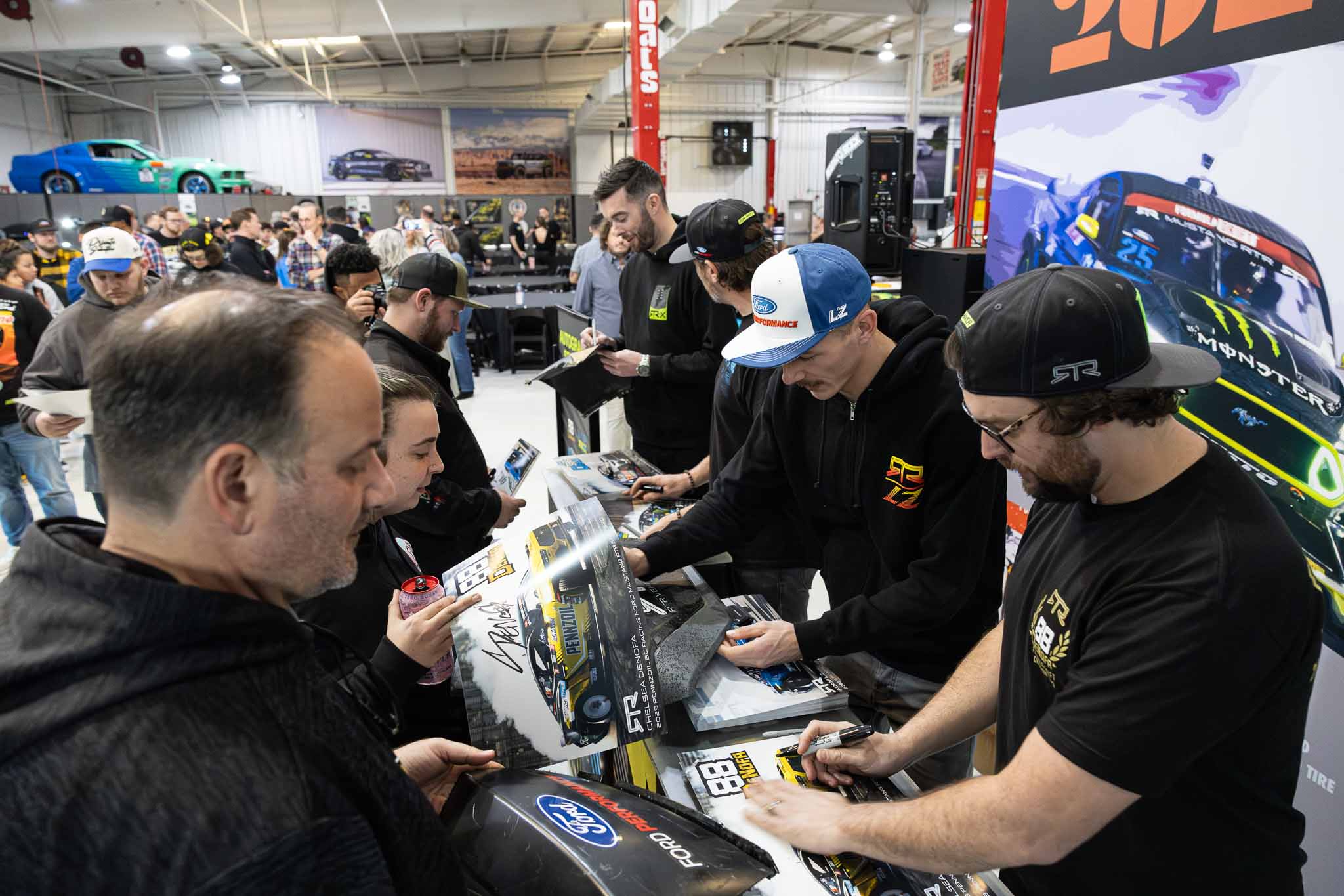 James Deane, Vaughn Gittin Jr., Adam LZ, and Chelsea DeNofa signing posters for fans
