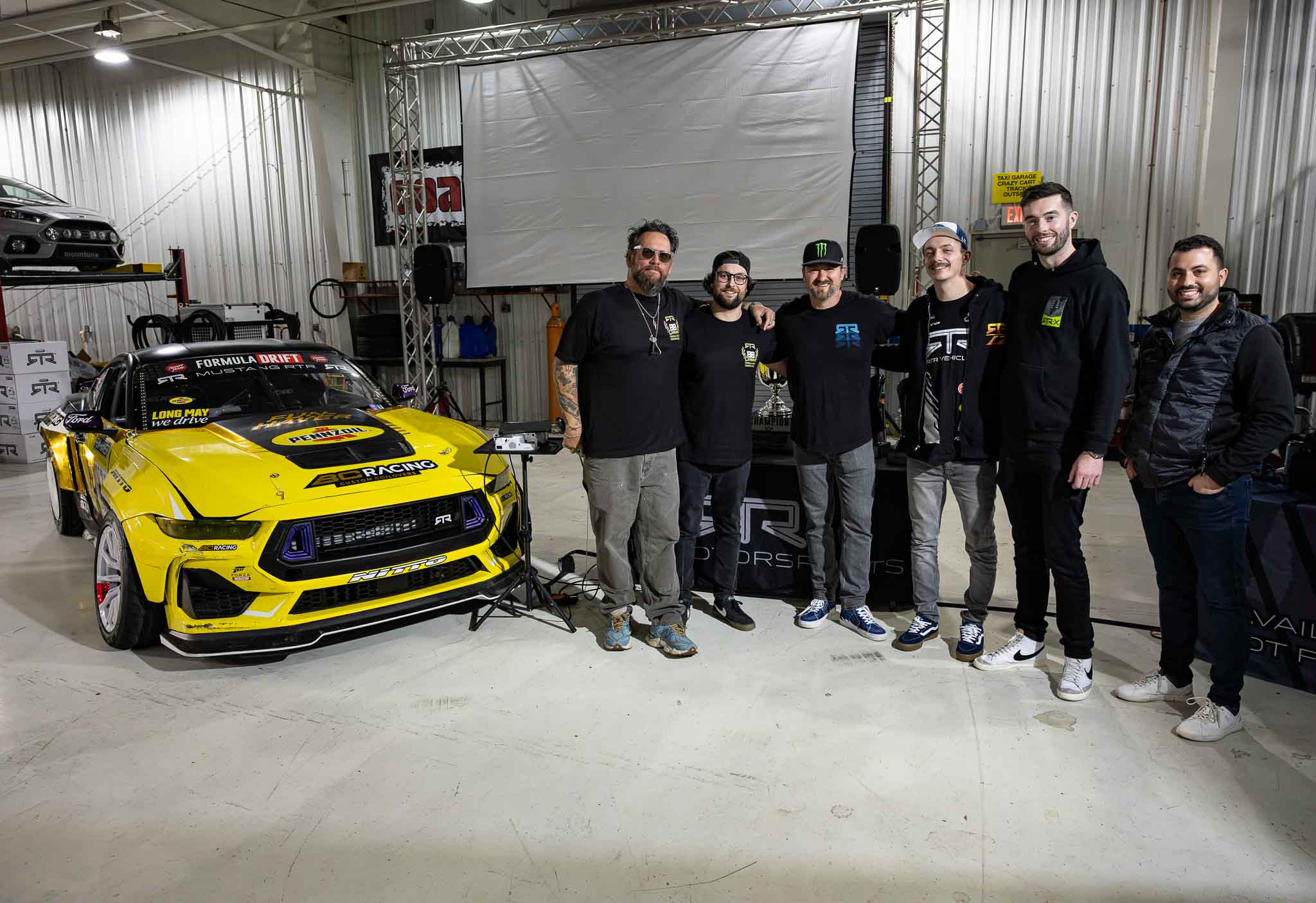The RTR team takes a group photo in front of the 2023 FD trophies and winning competition car.