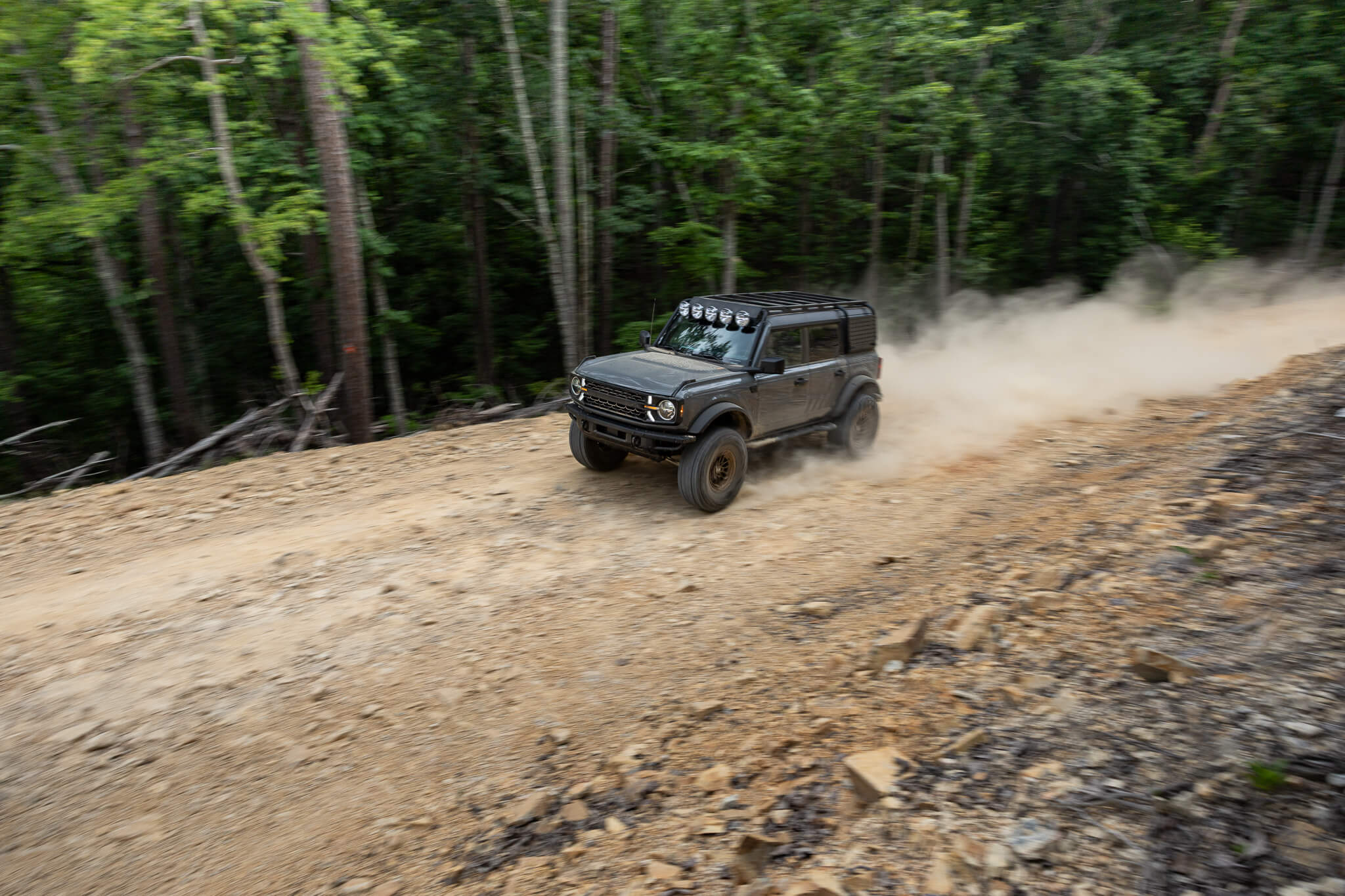 Ford Bronco RTR ROVR driving on a dirt trail through a forest
