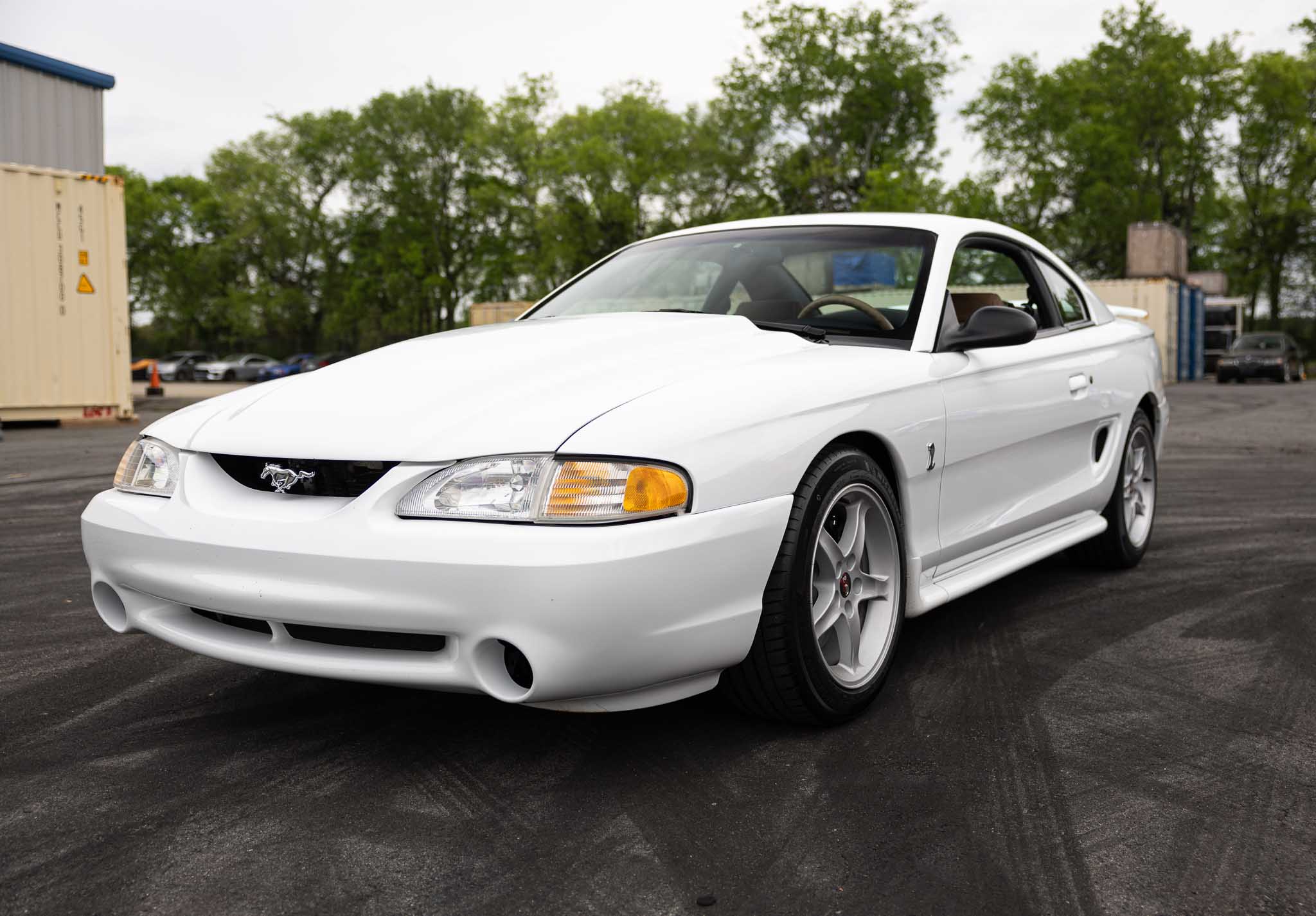 A white Mustang parked outside the RTR Lab