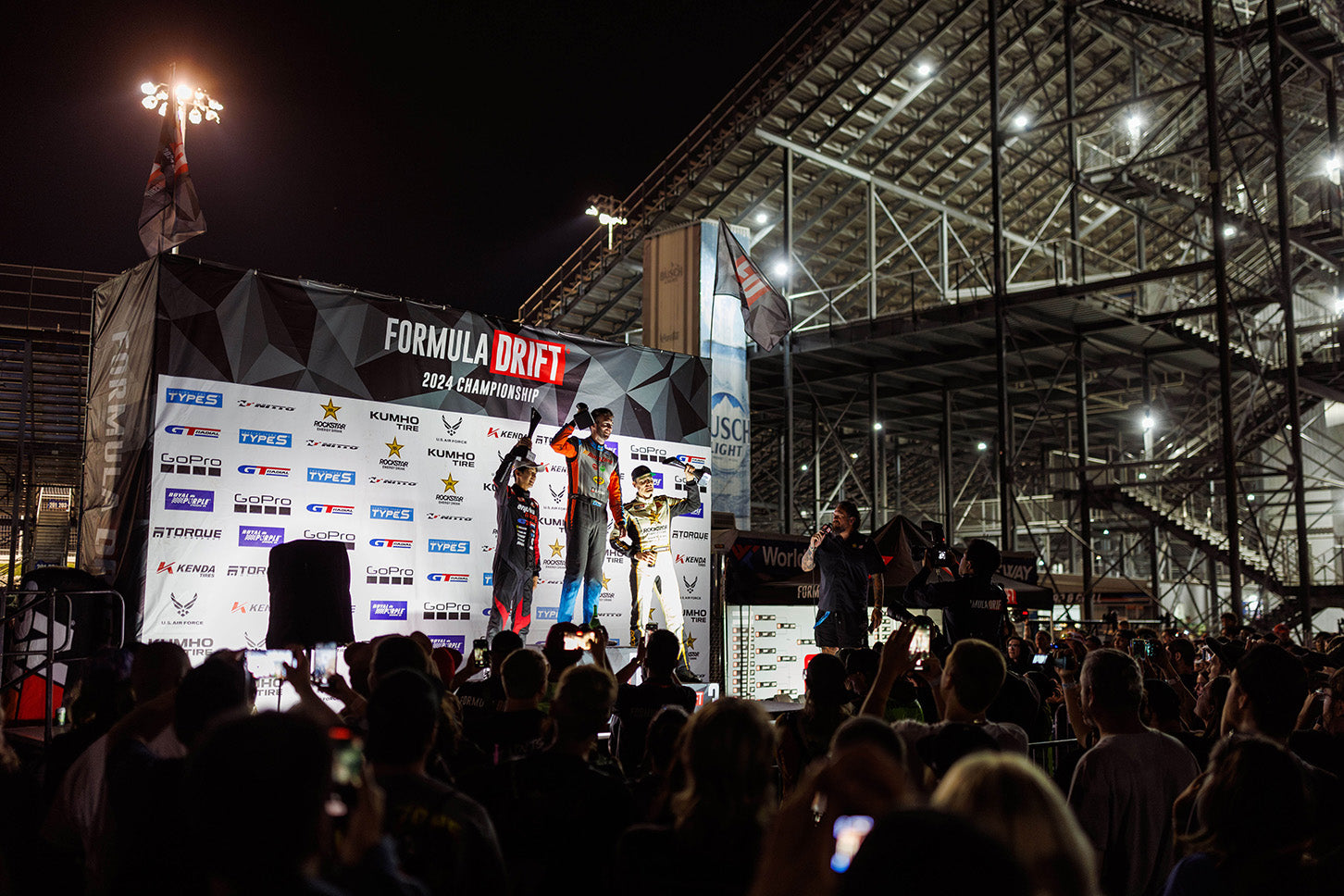 A crowd gathers around while James and the other drivers are rewarded with their trophies