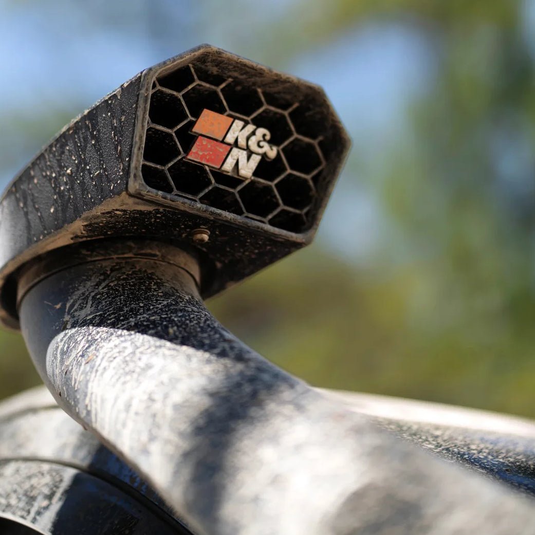 Close-up of a Bronco snorkel air intake with K&N logo against a blurred natural background