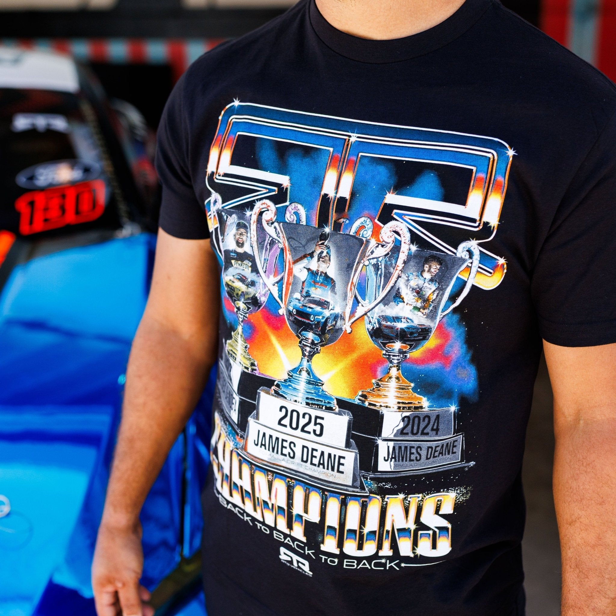 RTR Back To Back Champions T-Shirt featuring shiny trophies for James Deane's 2024 and 2025 wins, celebrating RTR Drift Team's dominance in Formula Drift.