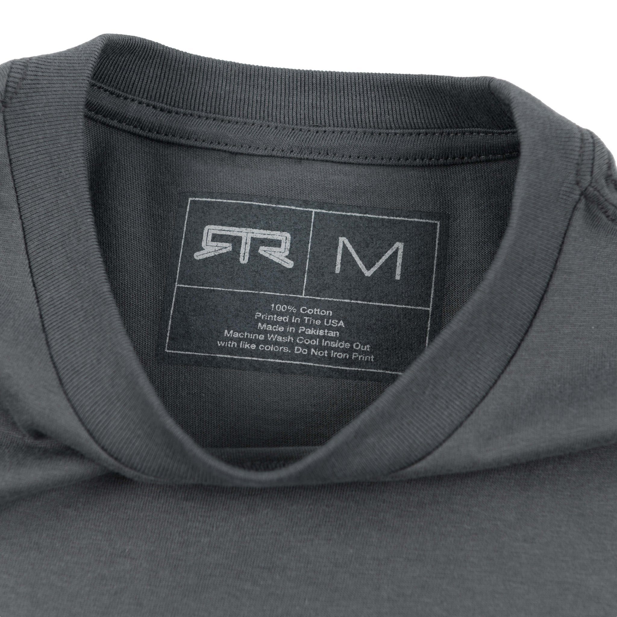Close-up of the RTR Heritage Badge T-Shirt, showcasing its bold graphic on charcoal cotton fabric, emphasizing the brand's ethos and modern style.