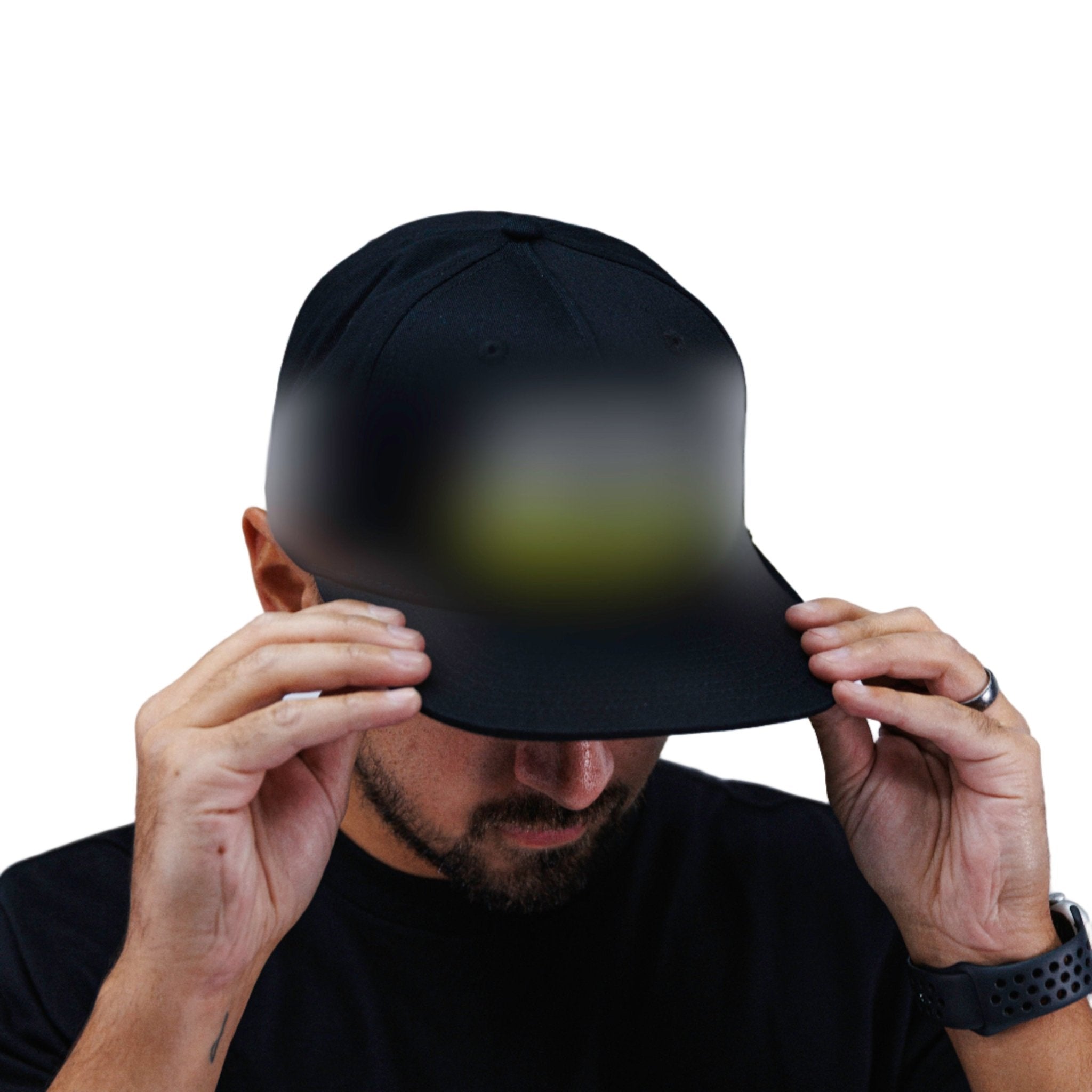 Person wearing a black cap and black t-shirt with a logo, holding the cap over their face against a white background.