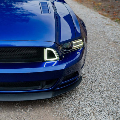 Close-up of RTR Signature LED Grille Lights on blue Mustang, showcasing sleek design with blacked-out grille and distinctive LED outline around the headlight.