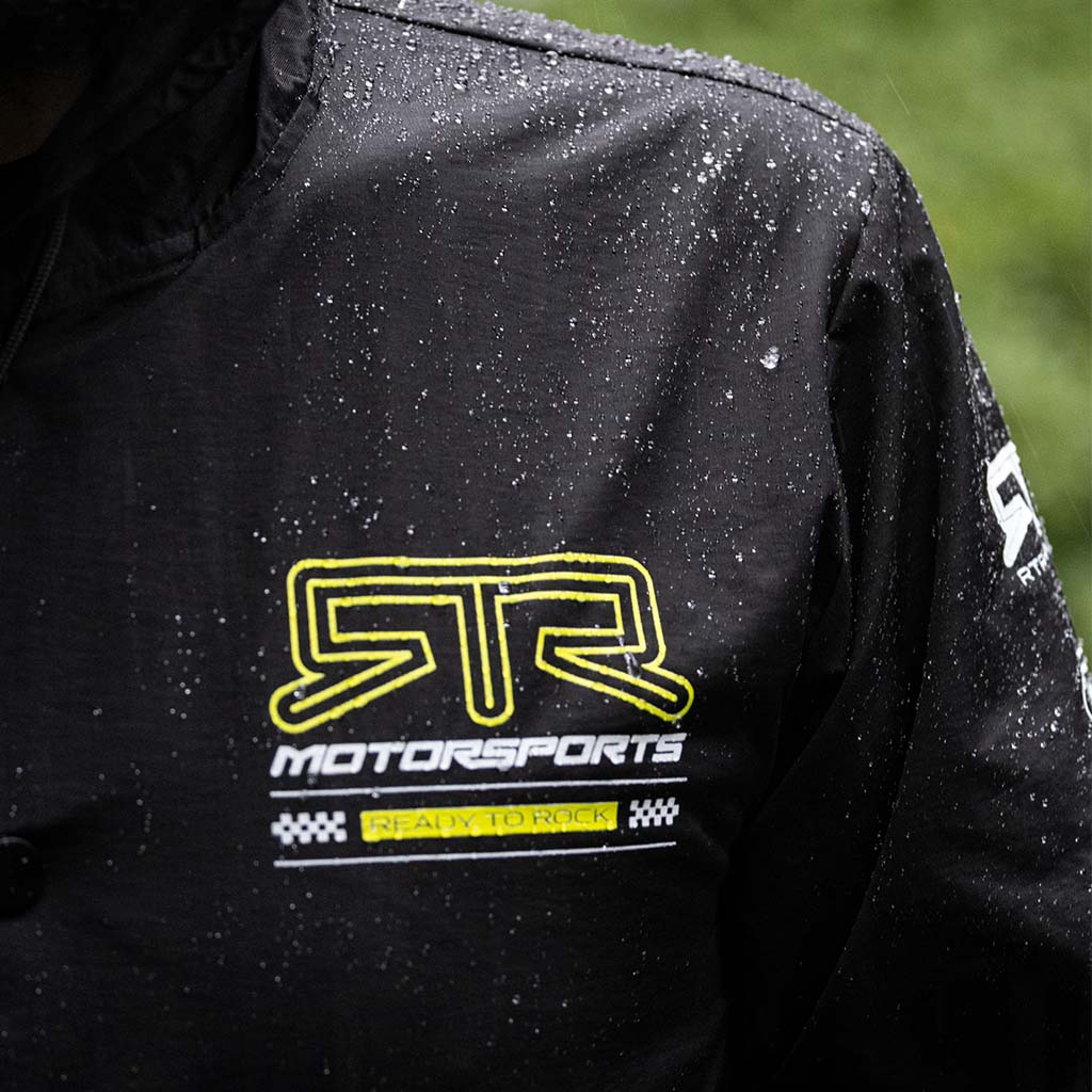 Close up front view of an RTR team member wearing the Black and Hyperlime RTR Motorsports Windbreaker Waterproof Jacket.