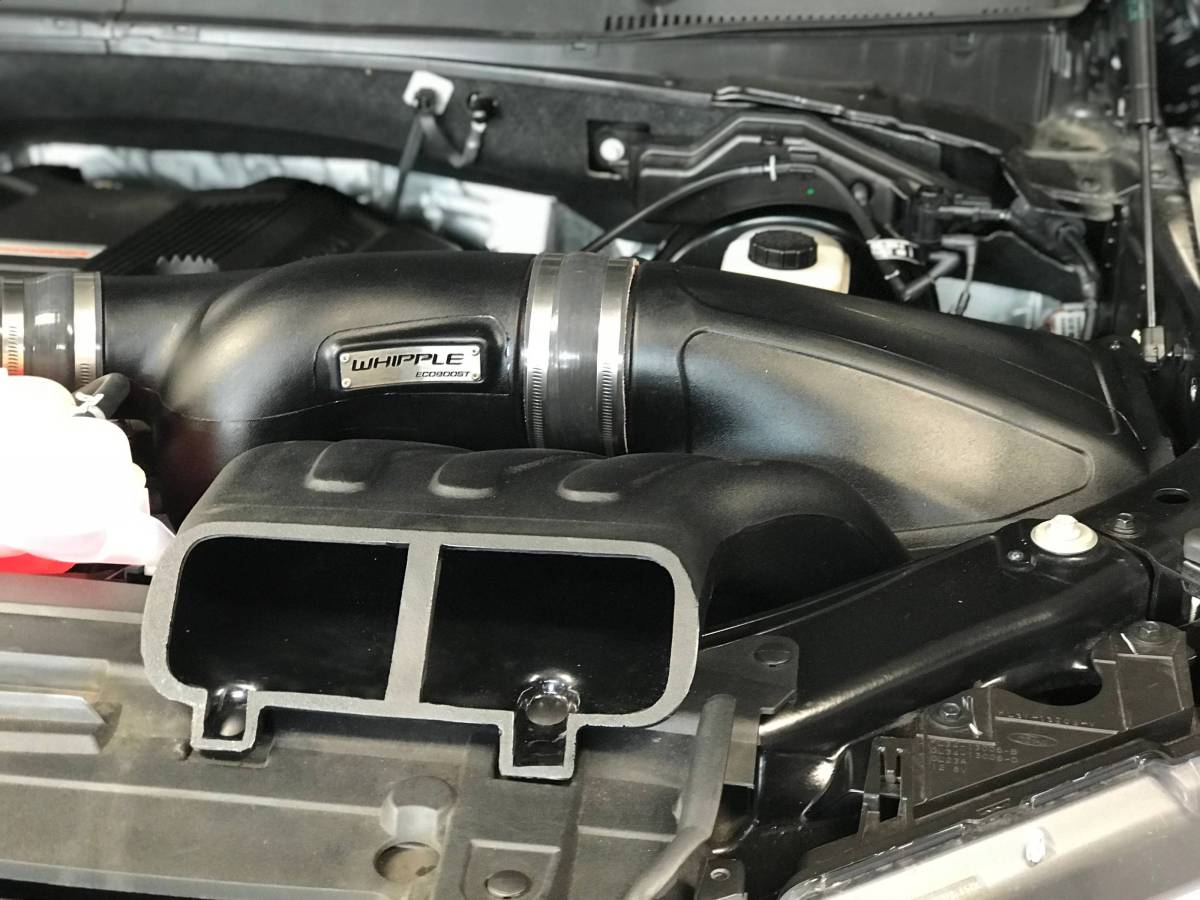 Whipple 3.5L EcoBoost Stage 1 Kit showcasing black intake ducting, Whipple EcoBoost badge on the supercharger, front air scoop, and visible coolant reservoir.