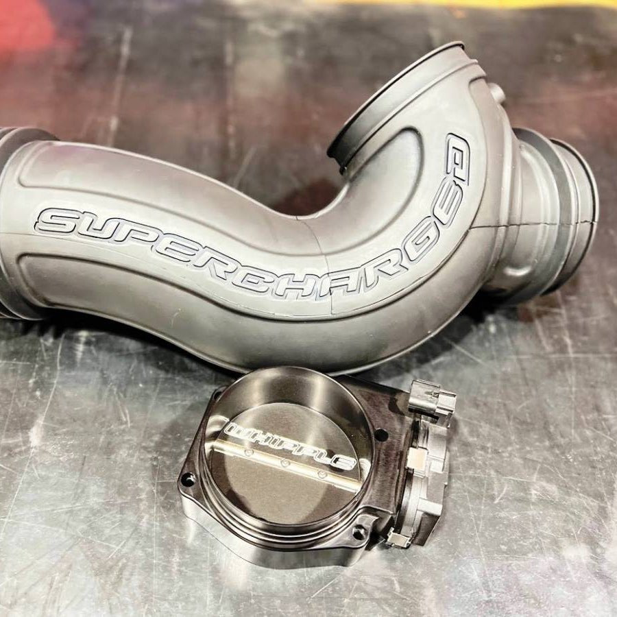 Metallic supercharger intake pipe on a metallic surface