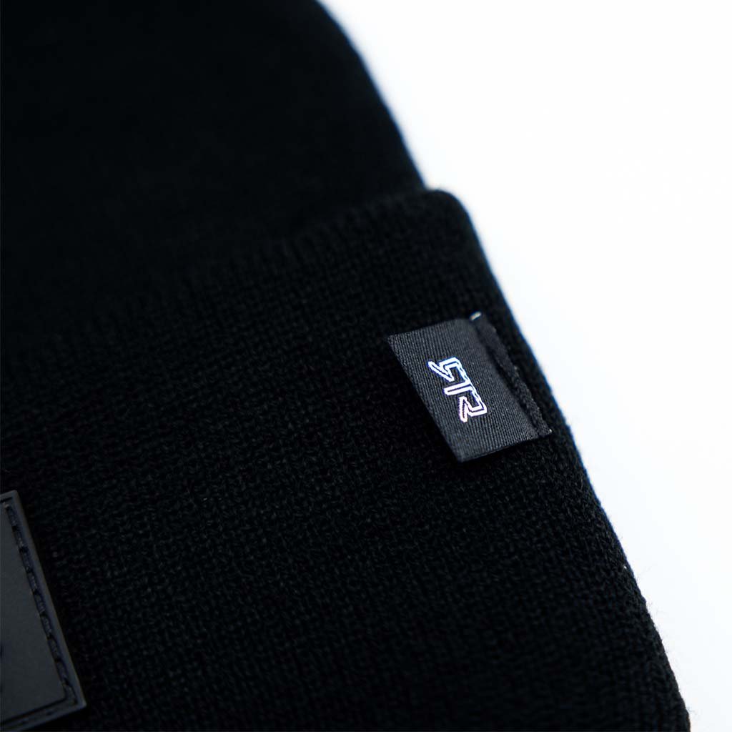 A black knit cap featuring a subtle black rubberized RTR logo and a smaller stitched RTR tag on the side. Designed for all head sizes, offering comfort and style for RTR enthusiasts.